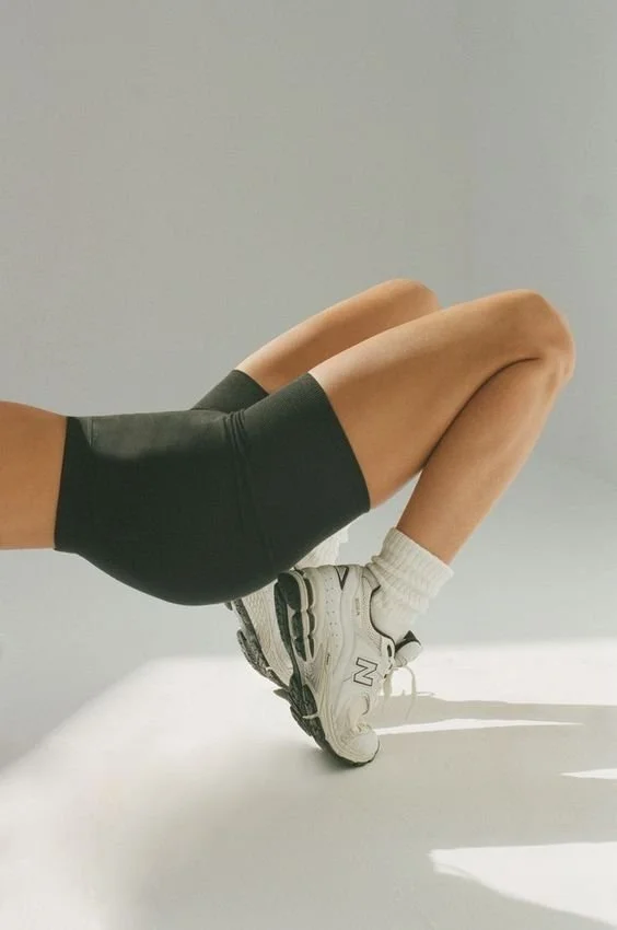Persona haciendo una flexión con las piernas dobladas y apoyada en las manos, usando ropa deportiva