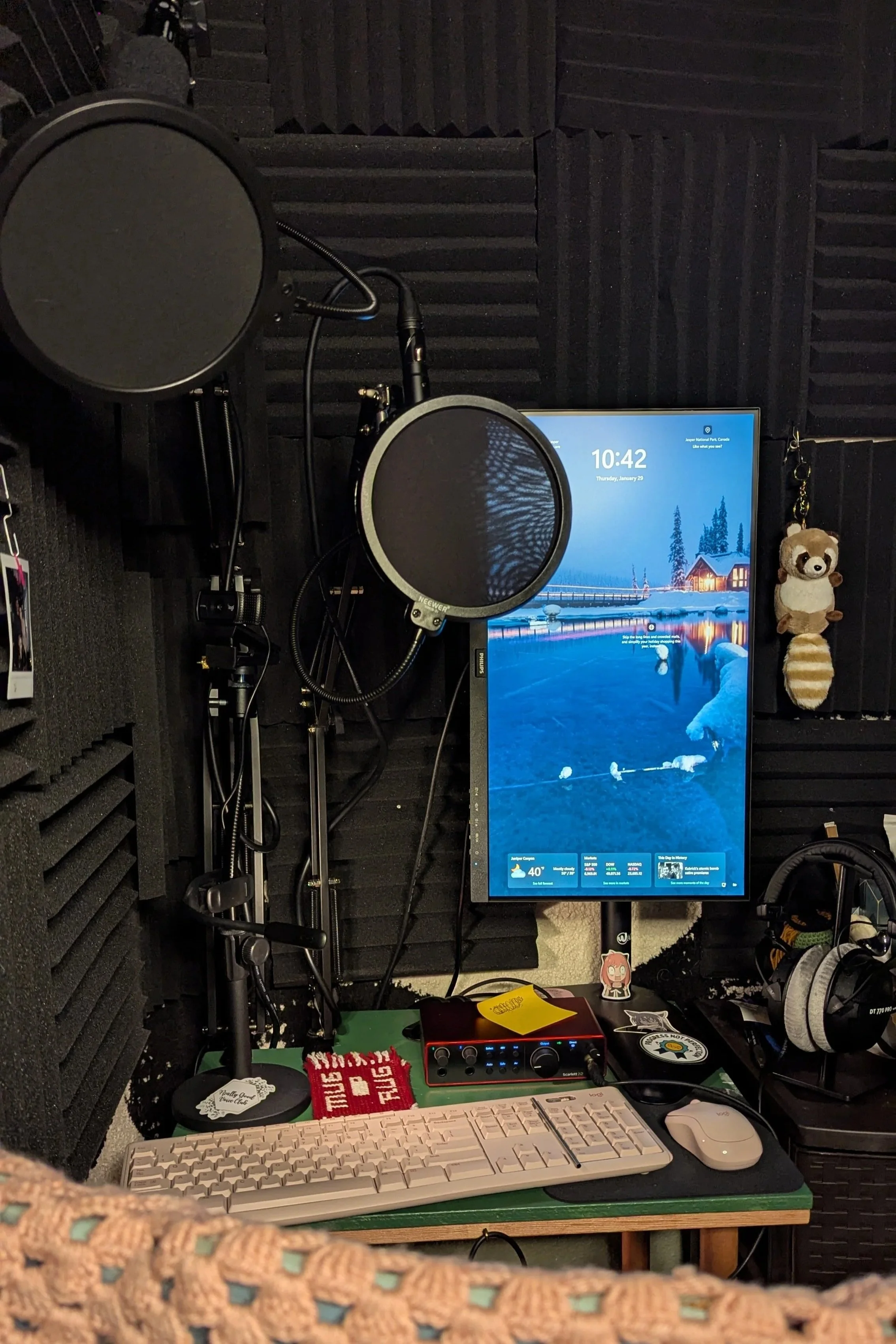 A picture of Kristen's recording studio. There are 2 mics, foam walls, a big screen, and other tech.