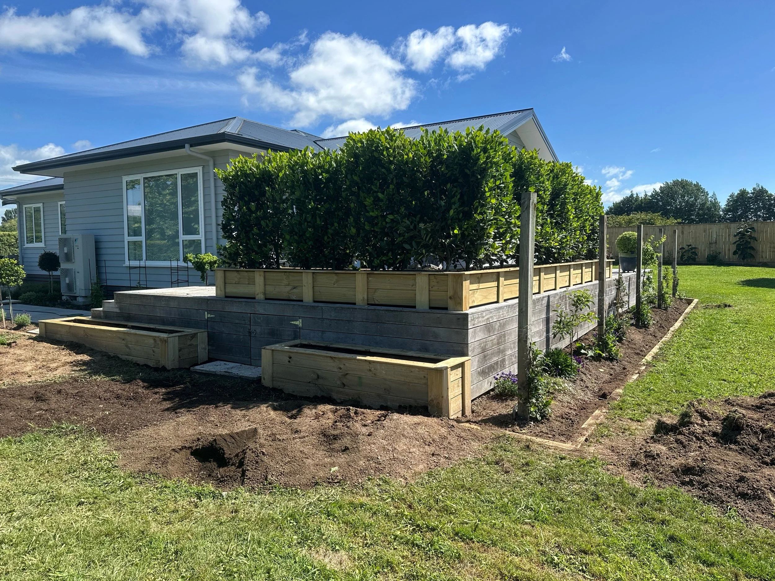 Backyard landscaping with raised timber garden bed, soil preparation and timber fencing