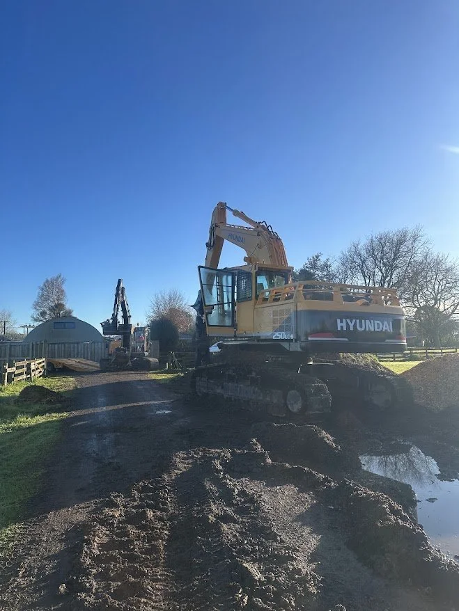 Hyundai excavator working on a muddy Waikato construction site with another excavator in the background