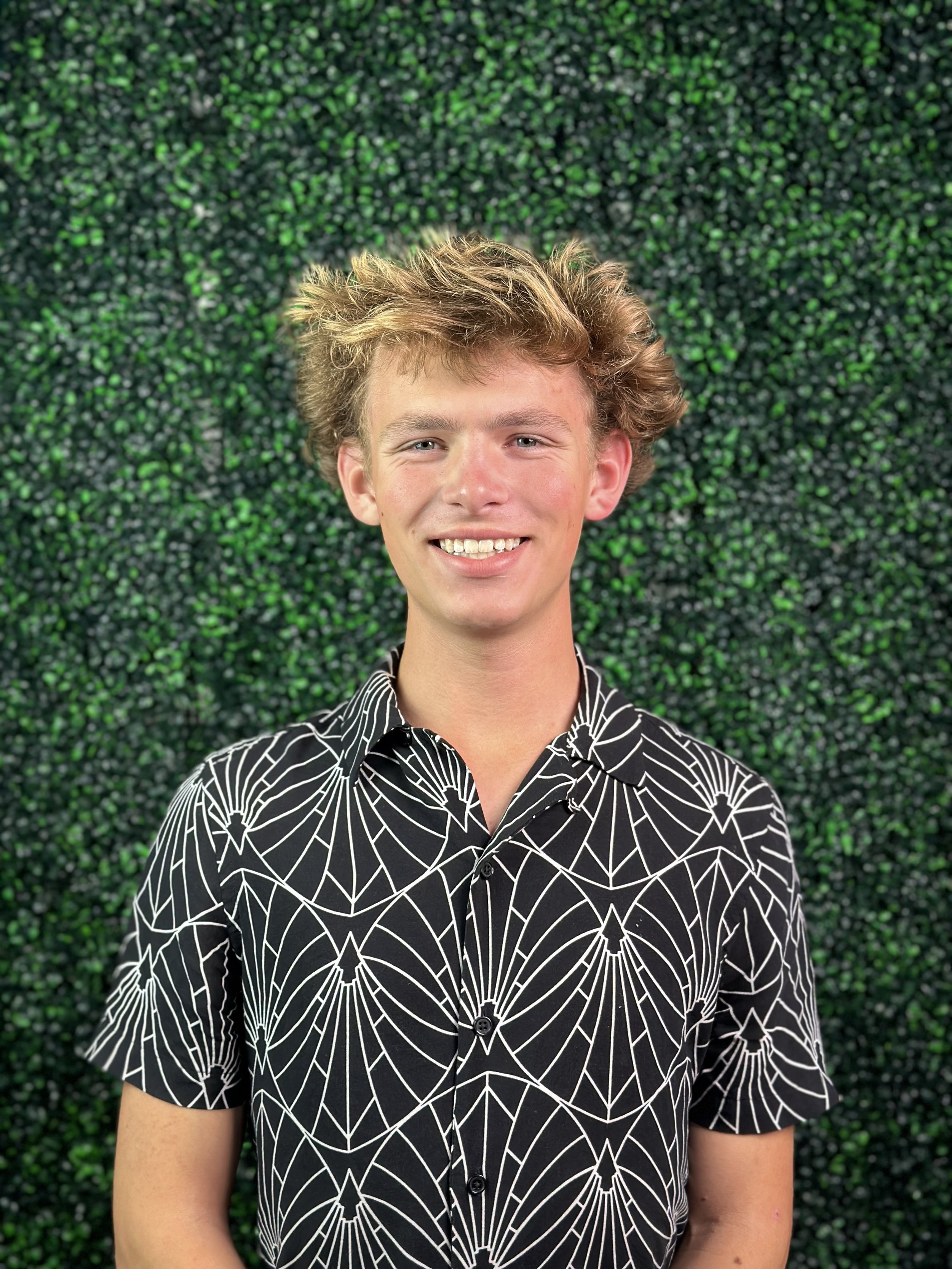 Brady, founder of Agency 805, a California-based marketing and branding agency, standing in front of a green wall at the Agency 805 office.