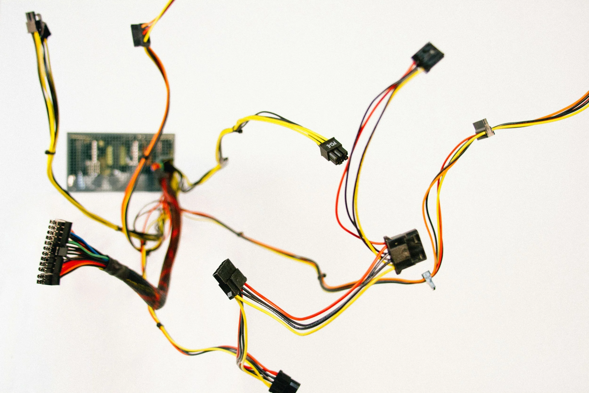 Computer hardware components, including various colored wires and connectors, arranged on a plain white background.