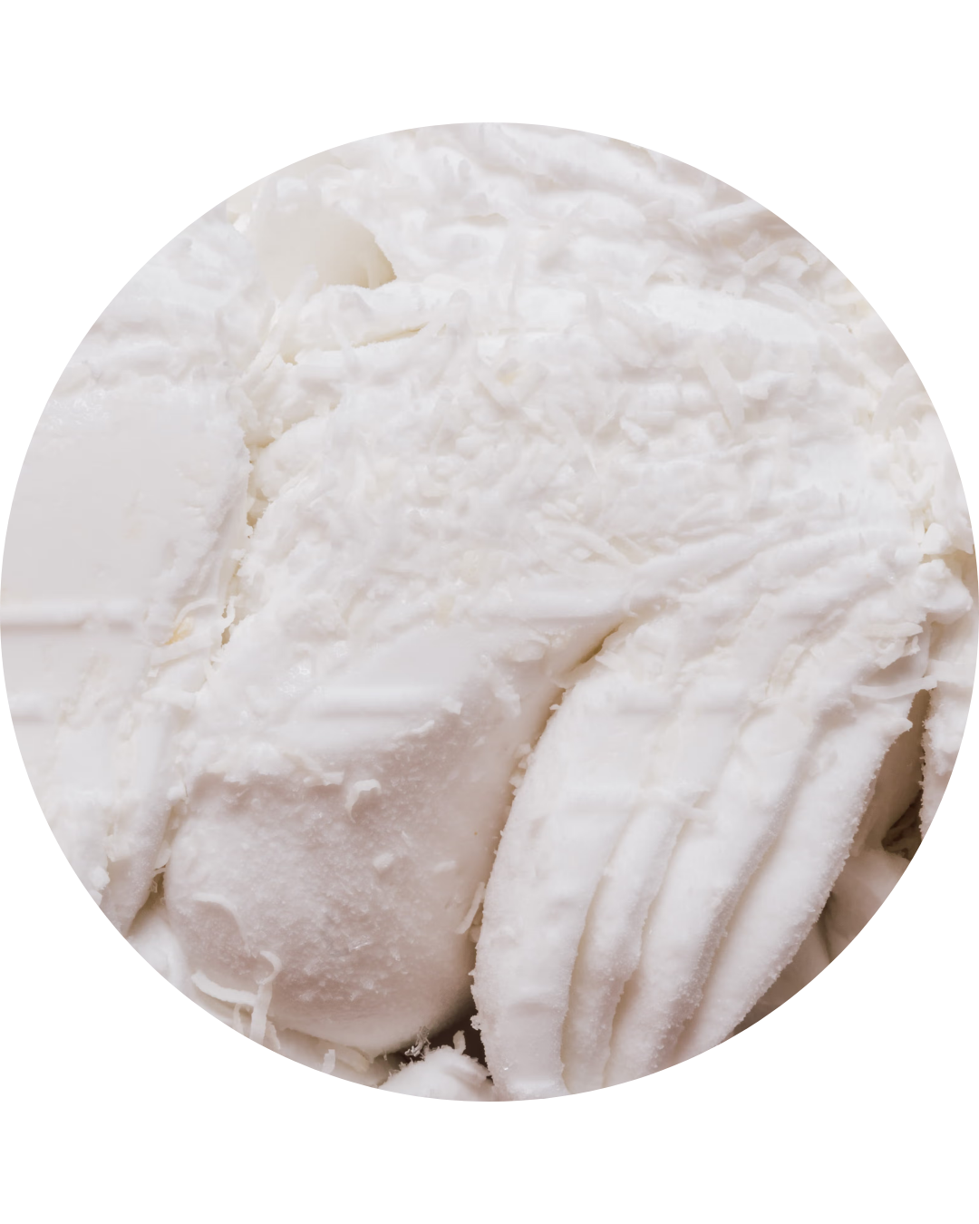 Close-up of white chocolate truffles with a smooth outer coating and sliced sections showing creamy interior.