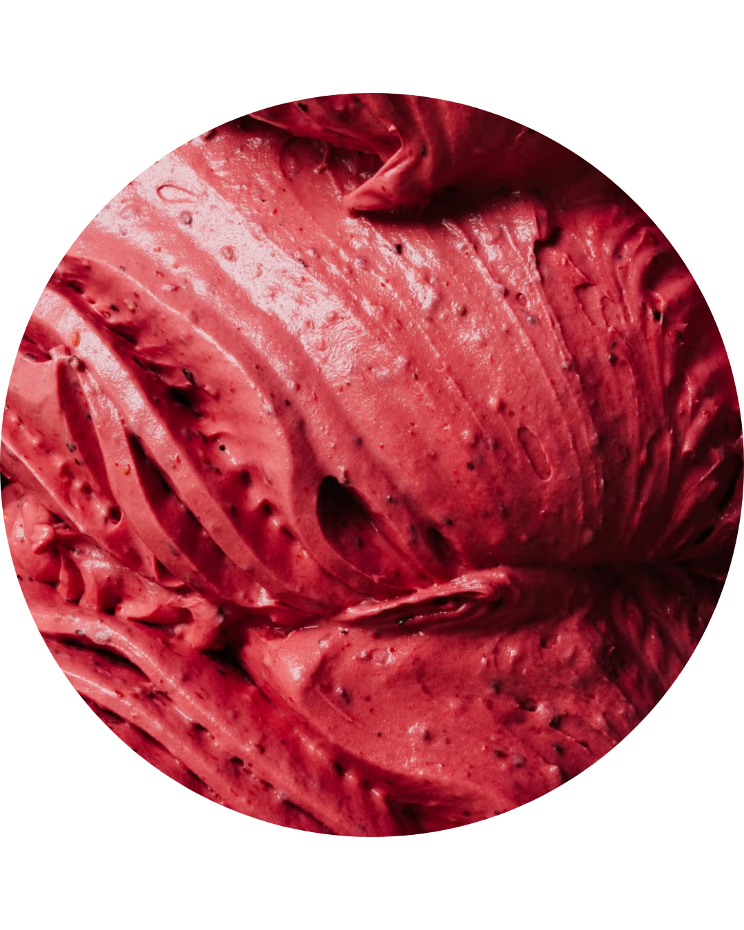 A close-up of a scoop of pink strawberry ice cream with visible seeds.