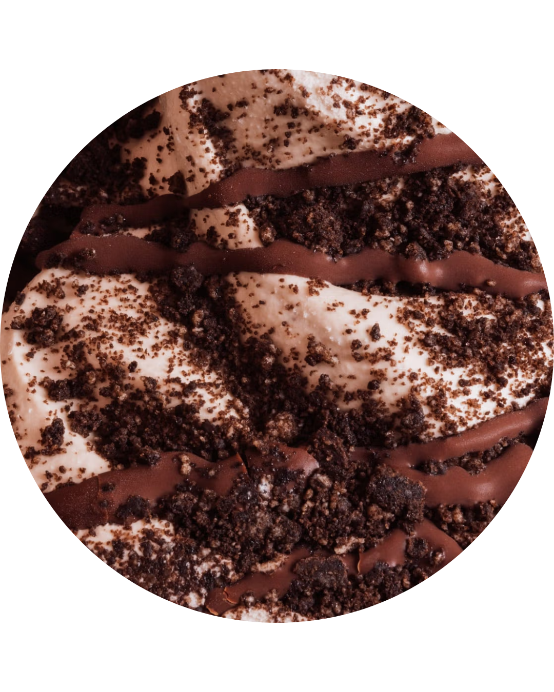 Close-up of a chocolate and vanilla ice cream topped with chocolate crumbs and drizzled with chocolate syrup.