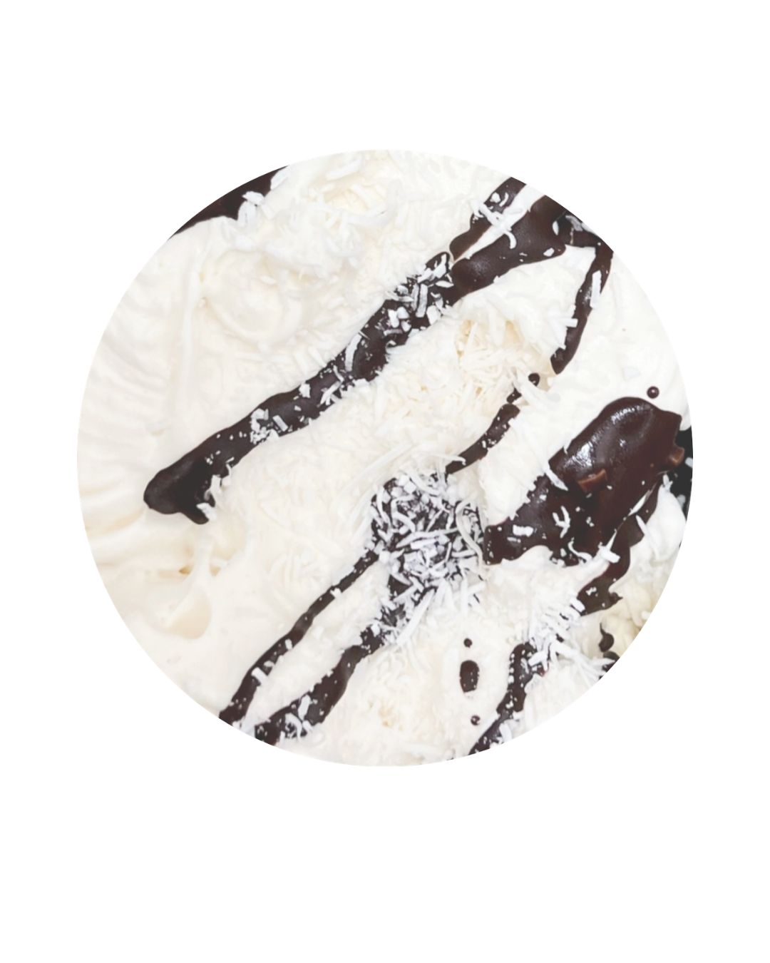 A round cake decorated with white icing, chocolate drizzle, shredded cheese, and white sprinkles.