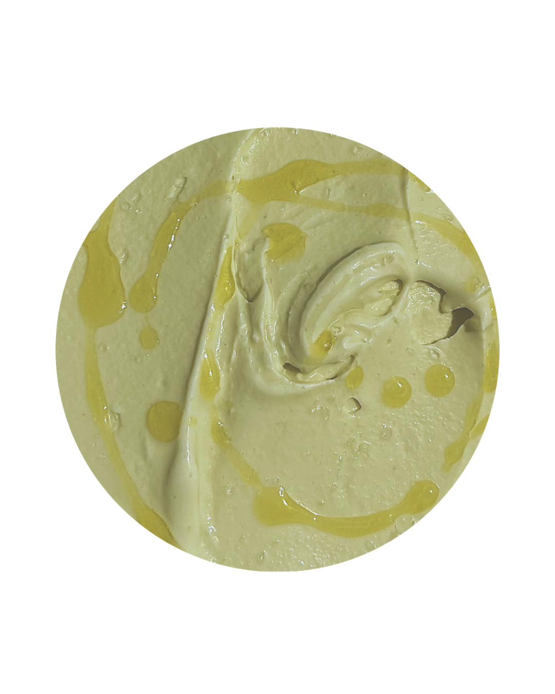 Close-up of a round swirl of vanilla ice cream with yellow syrup drizzled on top.
