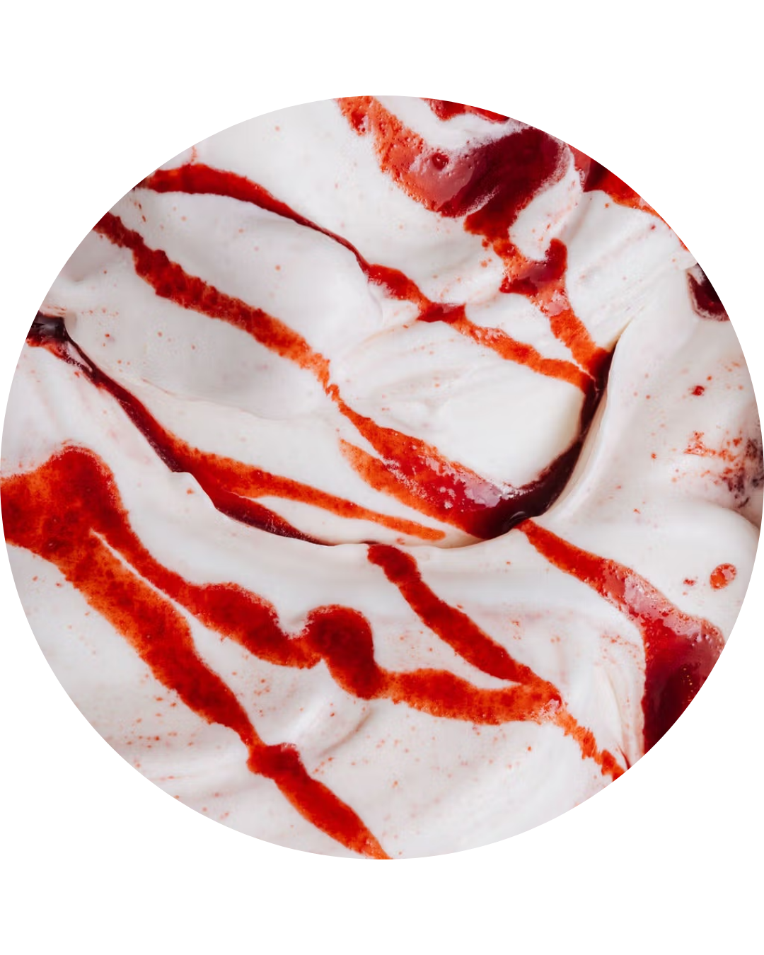 Close-up of whipped cream drizzled with red fruit syrup.