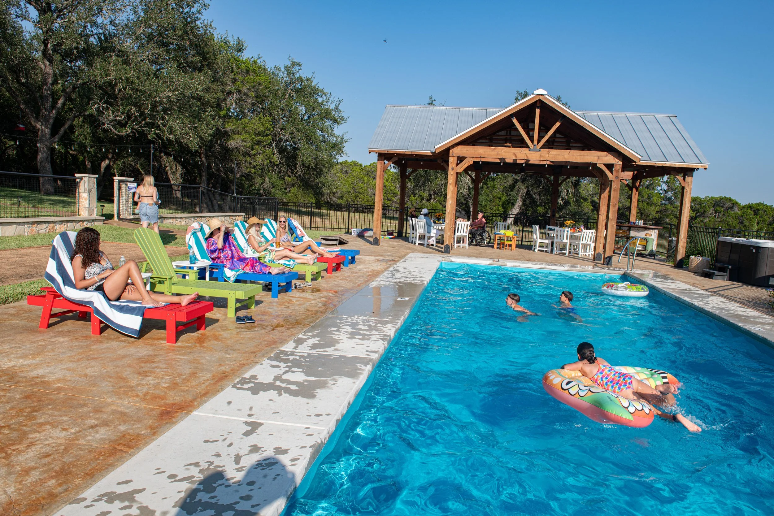 Guests enjoying the pool and covered pavilion at The Gathering in Wimberley, Texas.