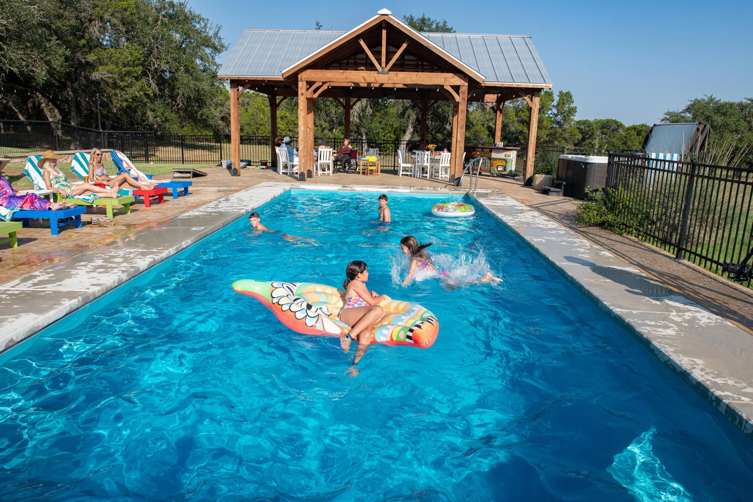 Family enjoying the swimming pool and pavilion at The Gathering in Wimberley.