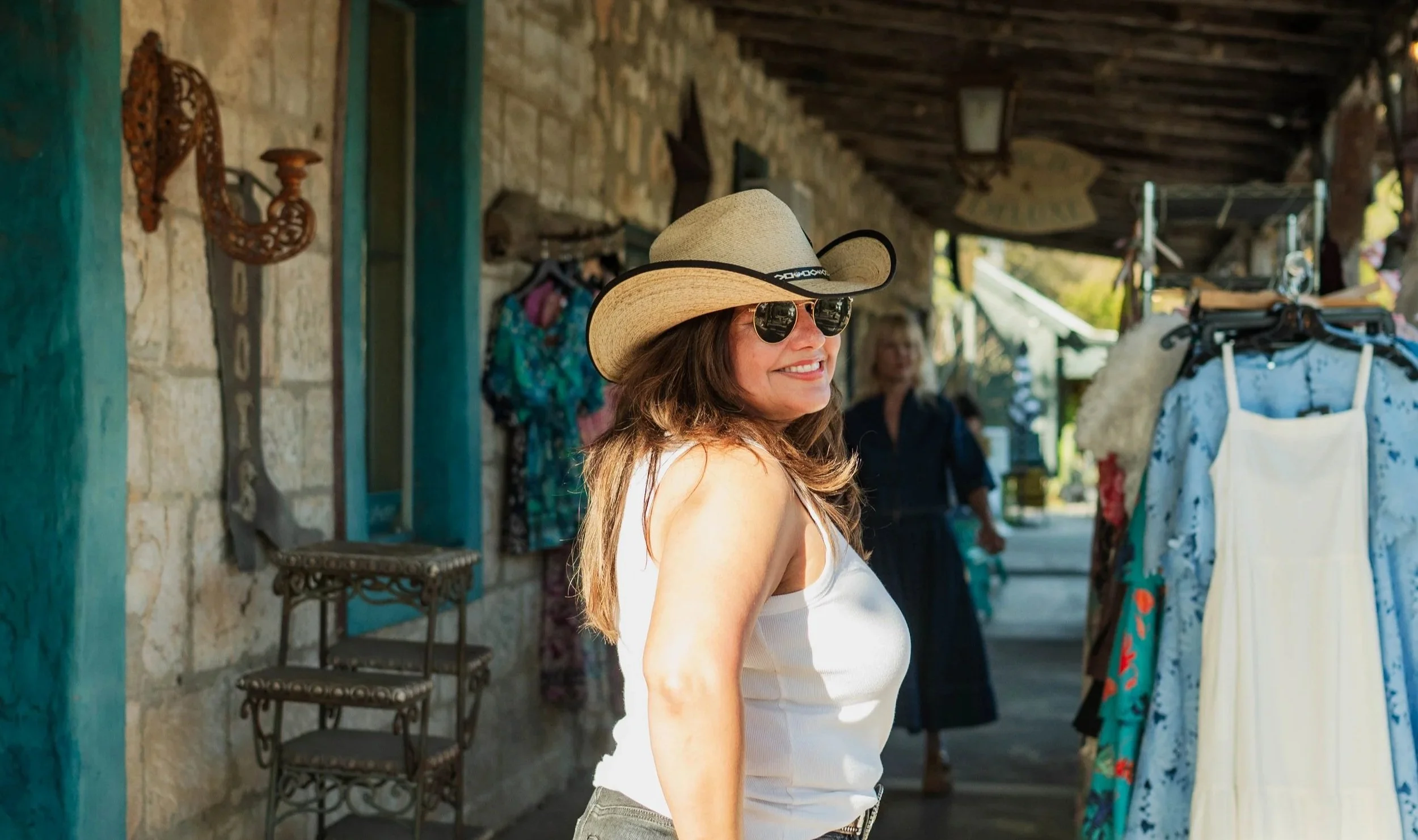Woman in a cowboy hat browsing shops in Wimberley, Texas.