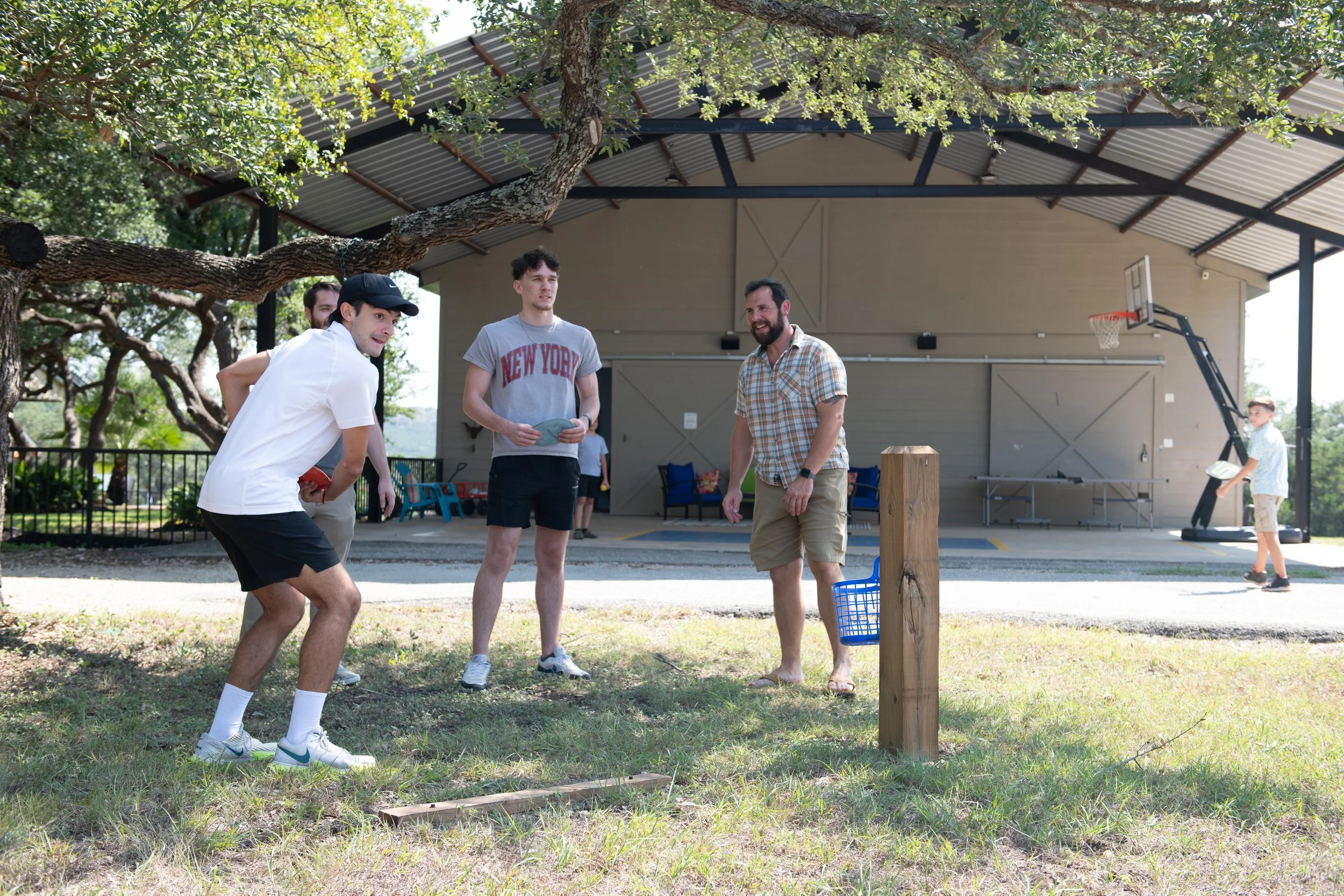 Family playing an outdoor game together near the Party Barn at The Gathering in Wimberley, Texas.