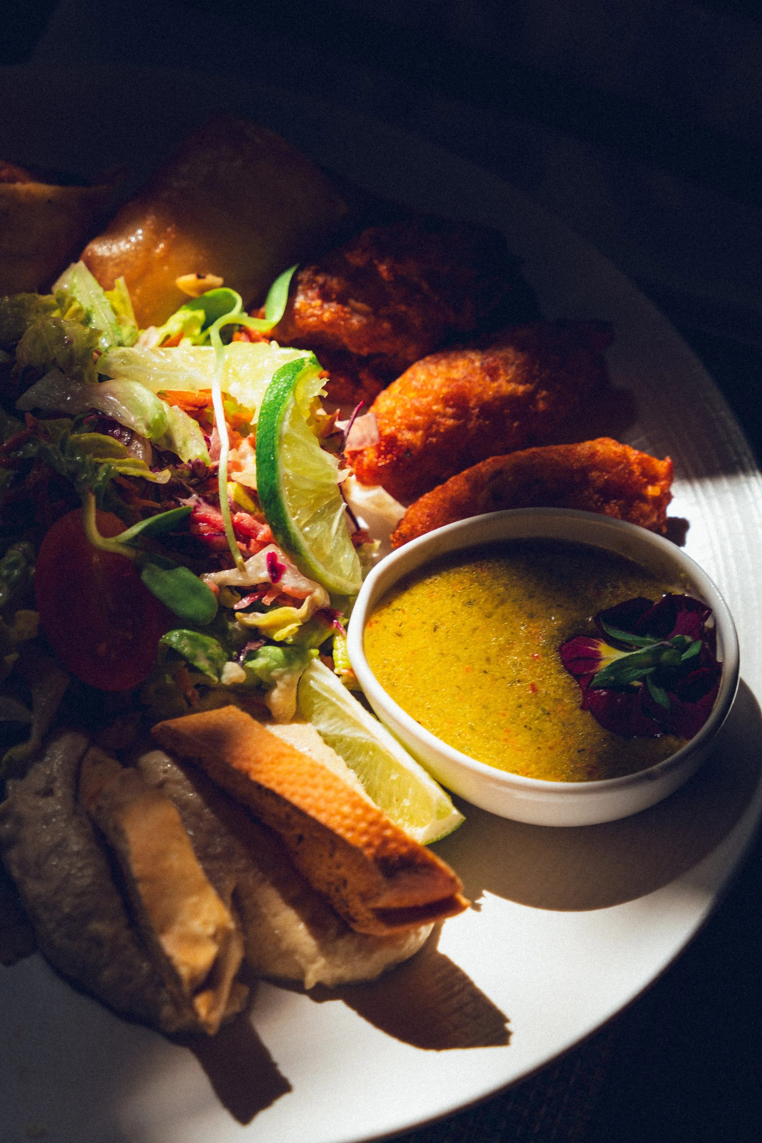 Assiette de plats indiens avec poulet tikka, ketchup, salade et sauce au curry.
