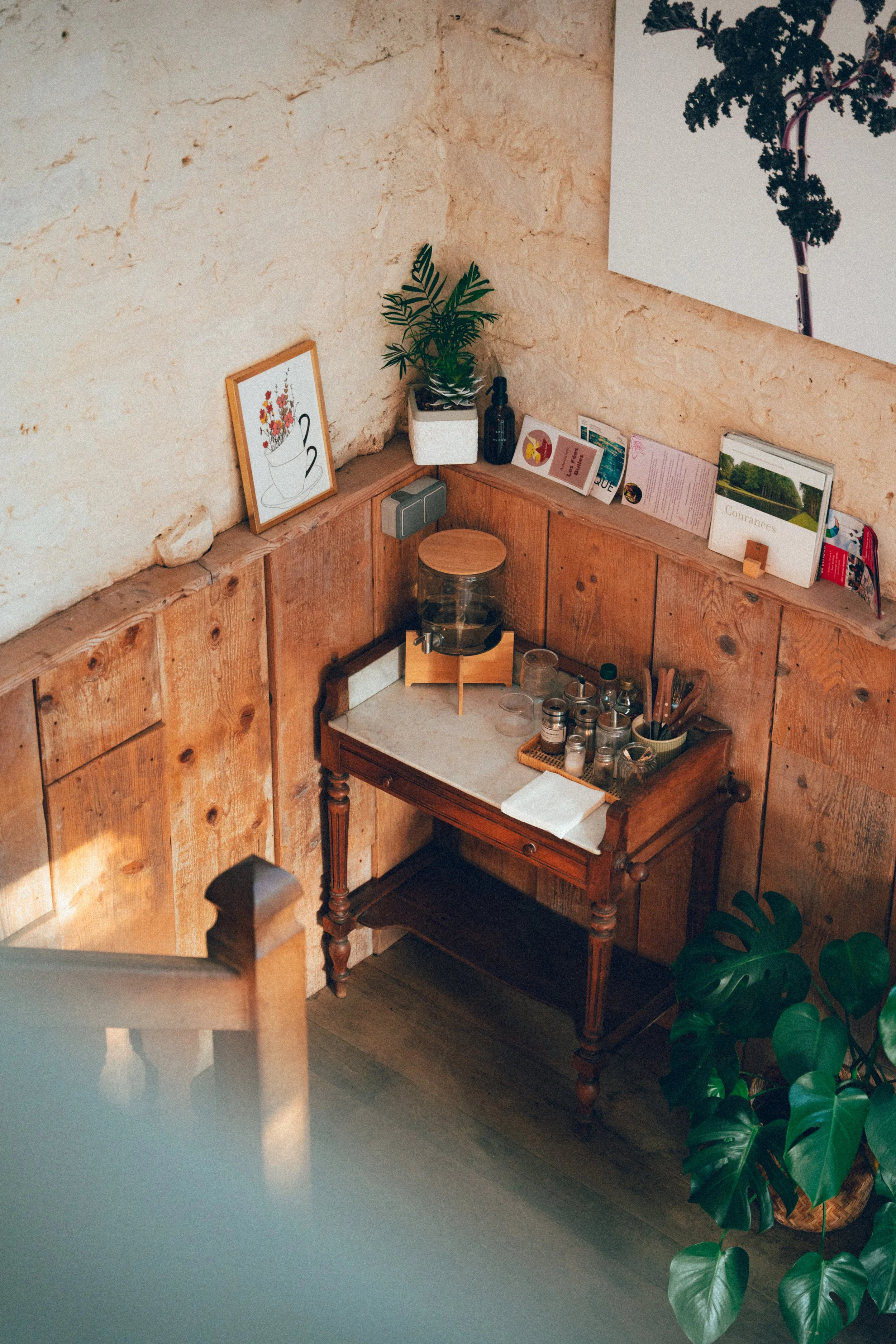 Vase de fleurs, plantes vertes, livres, décoration dans une pièce chaleureuse en bois et pierre.