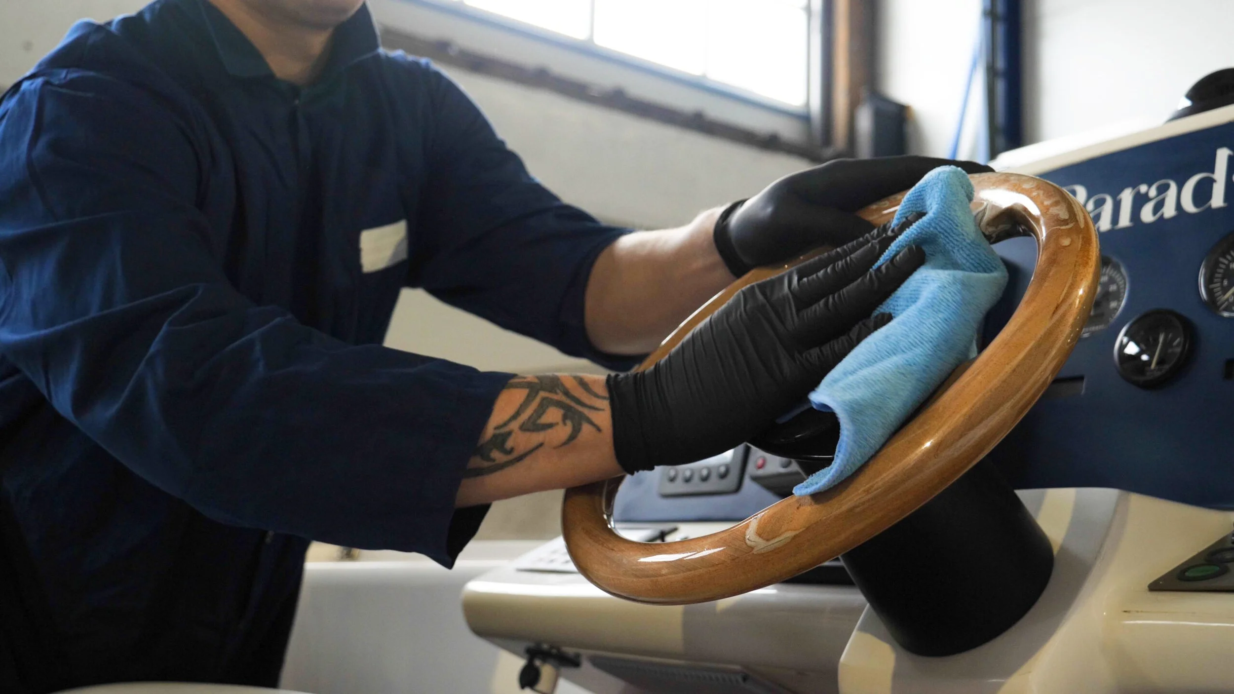 Professional marine interior detailing on Cayuga Lake, featuring a man wiping down the steering wheel on a luxury boat in Ithaca, NY, by Results Detailing and Pressure Washing.