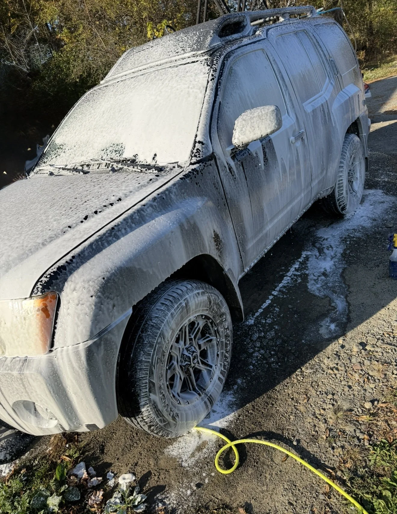 A Nissan SUV covered in thick snow foam during a professional hand wash and exterior detail by Results Detailing and Pressure Washing in Trumansburg, NY.