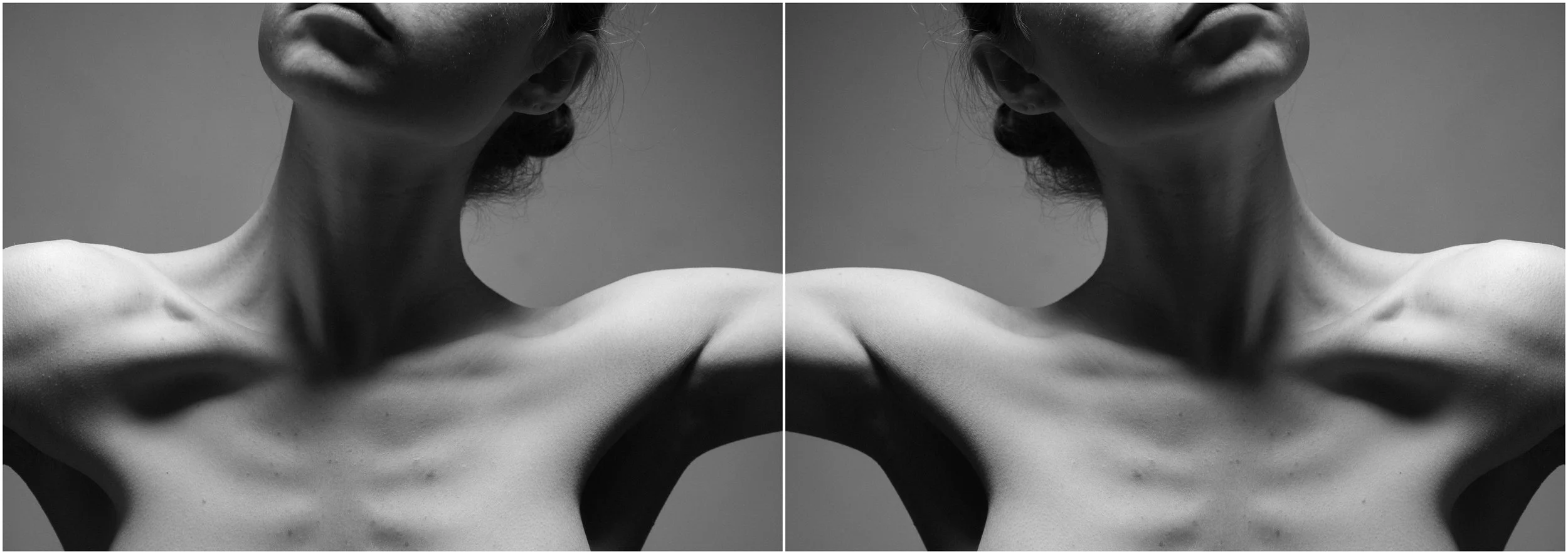 A black and white mirror-reflection photographic portrait of a young woman. A close-up. The clavicule, neck and the chest articulations showcased. Very strong shadows and contrasts.