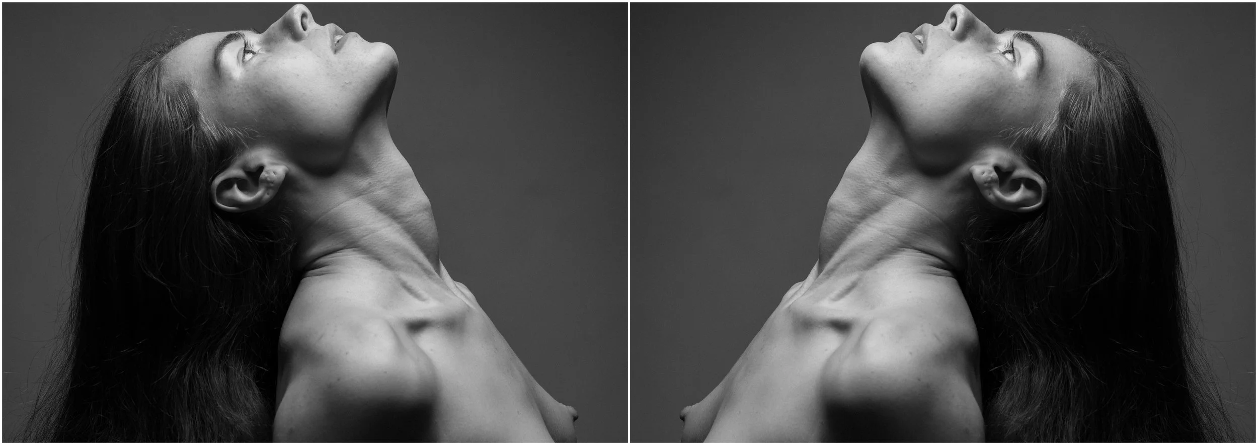 A black and white mirror-reflection photographic portrait of a young woman. A close-up. She is looking up, her profile is visible. Very strong shadows and contrasts.