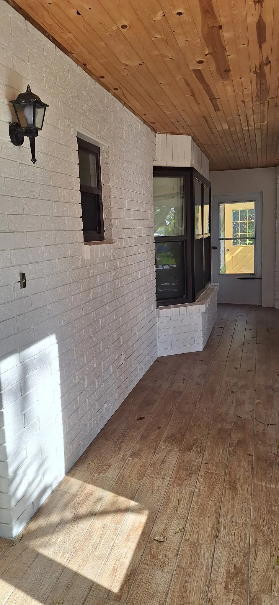 Freshly painted white brick on a covered patio area, enhancing the coastal feel of this New Smyrna Beach home.