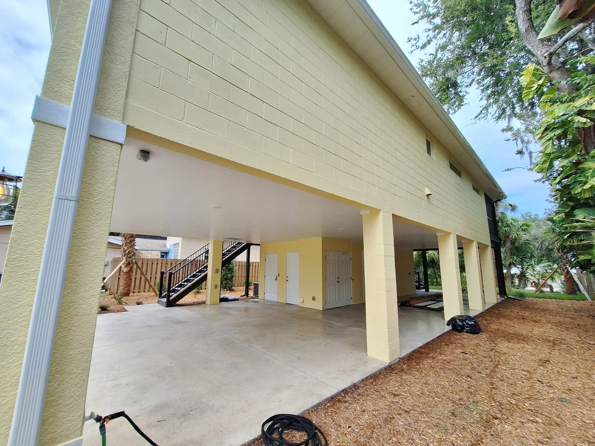 This view shows the fully painted side elevation, including columns and masonry walls, designed to withstand Florida’s sun and moisture while maintaining a polished look.
