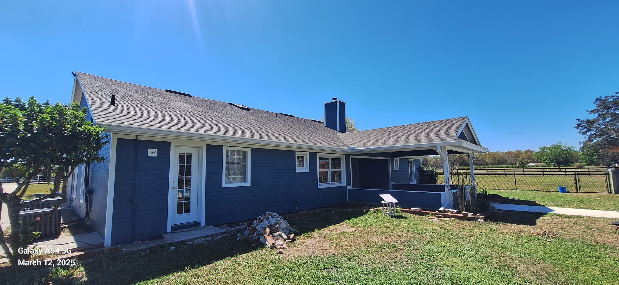 Side elevation of a Marion County Florida home painted with rich coastal blue siding and bright white trim highlighting the clean modern architecture.
