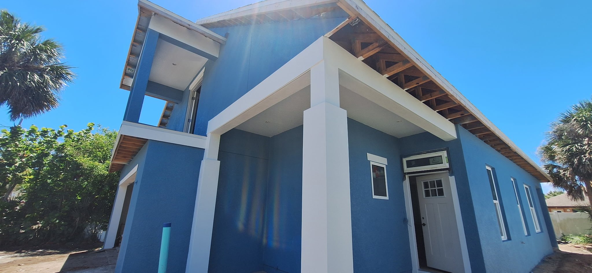 Side entry walkway of blue coastal home with white trim New Smyrna Beach