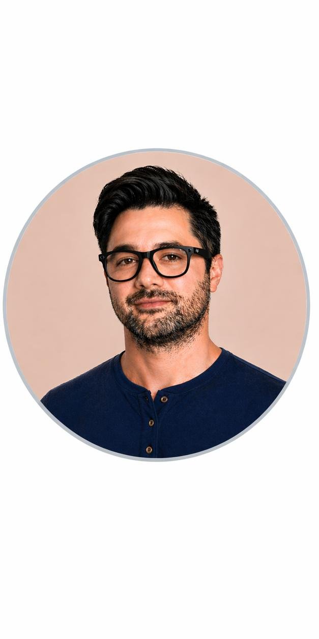 A man with glasses and dark hair, wearing a navy henley shirt, looking directly at the camera with a neutral expression.