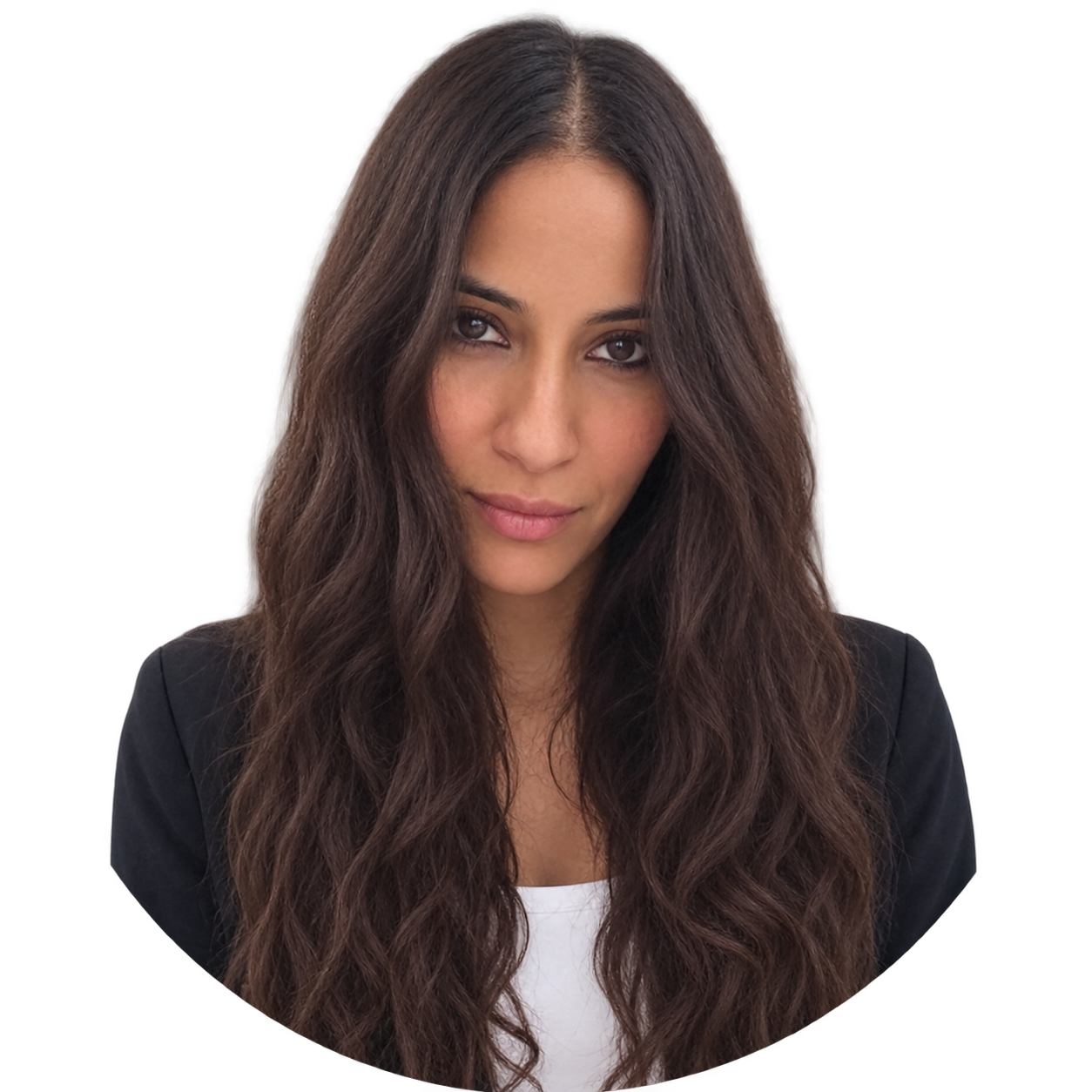 A woman with long, wavy brown hair looking at the camera with a slight smile, wearing a black blazer over a white top.