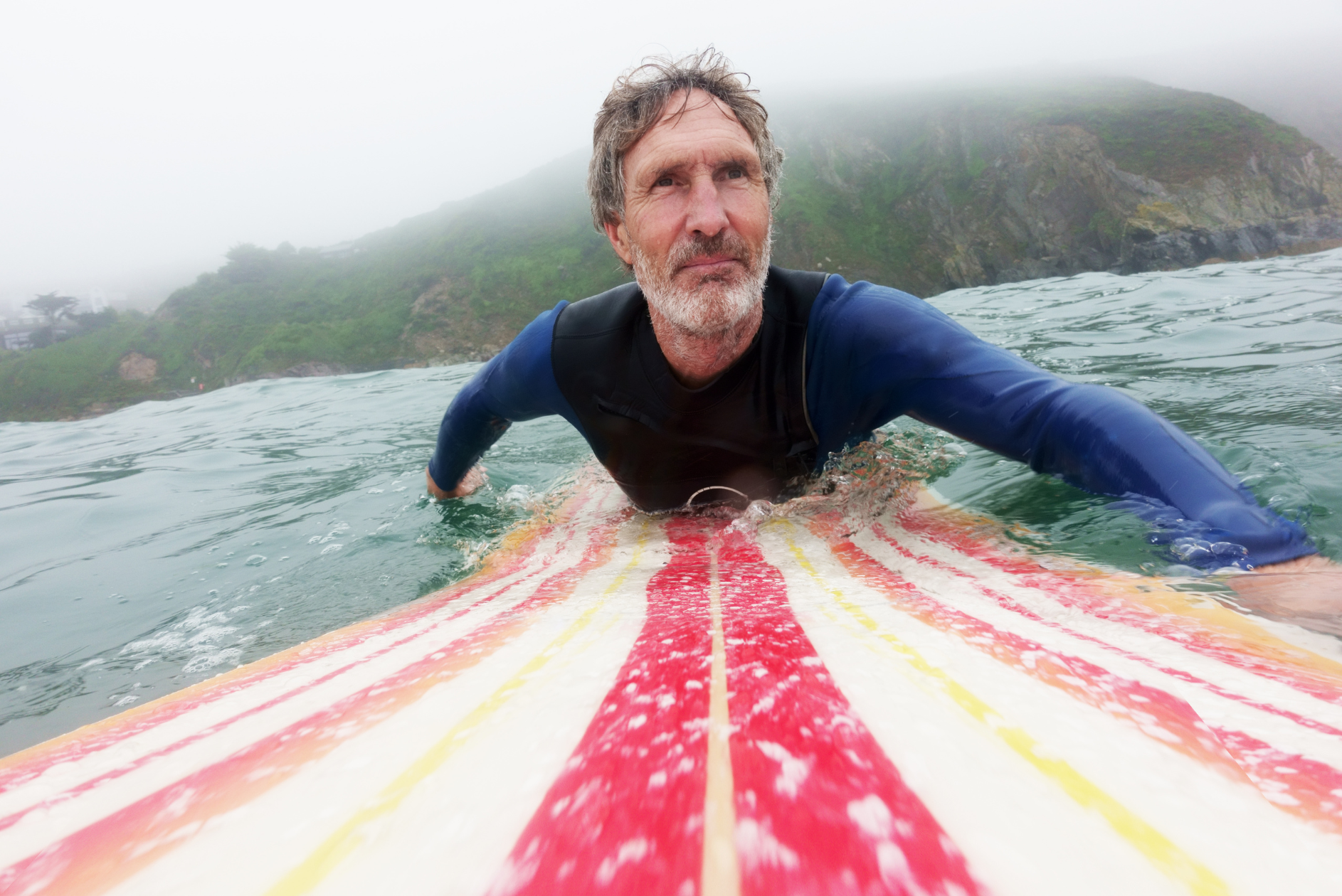 Elderly person enjoying waves safely, reflecting protection and peace of mind