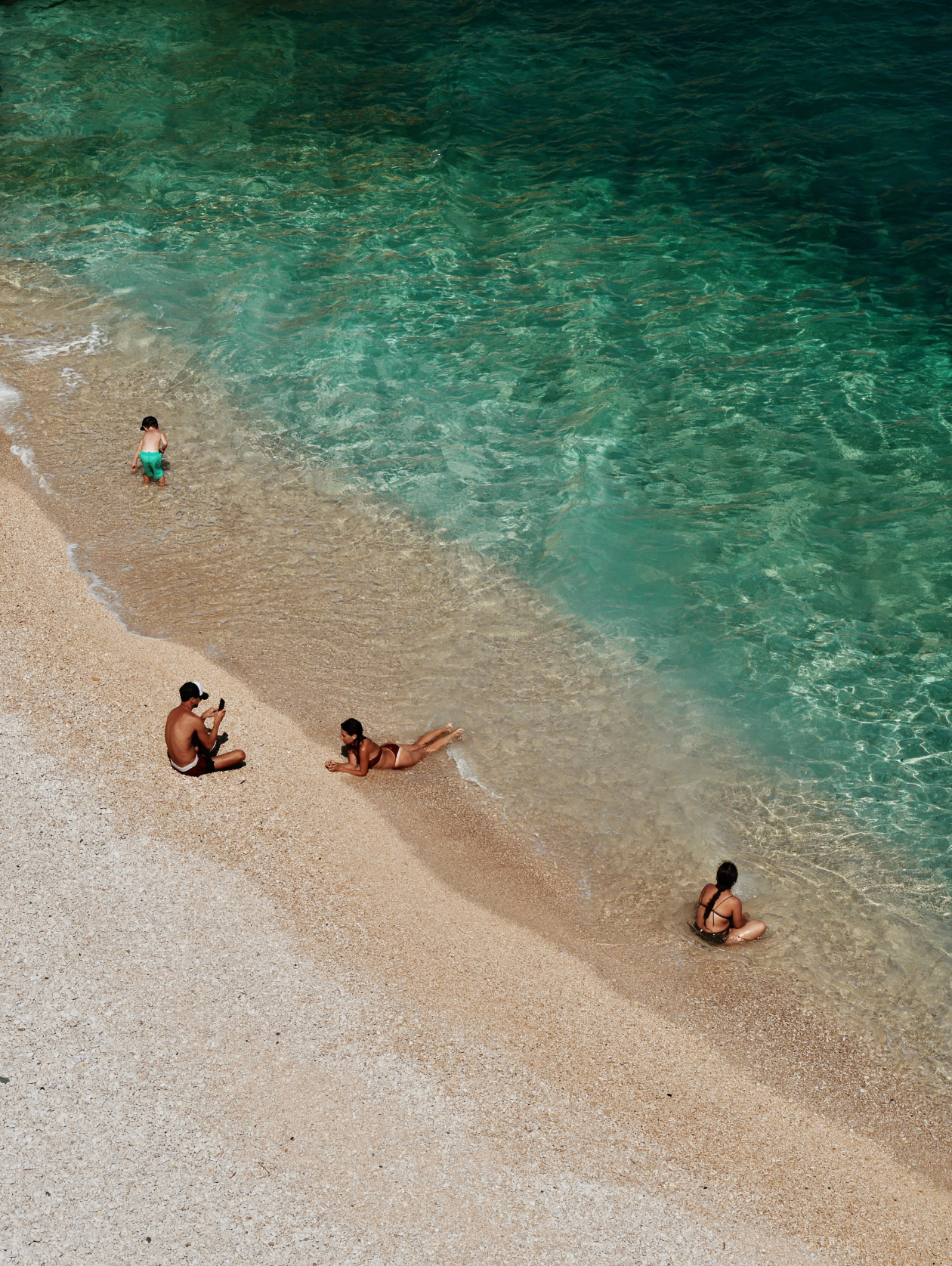 “Joyful family moment under the sun by the ocean