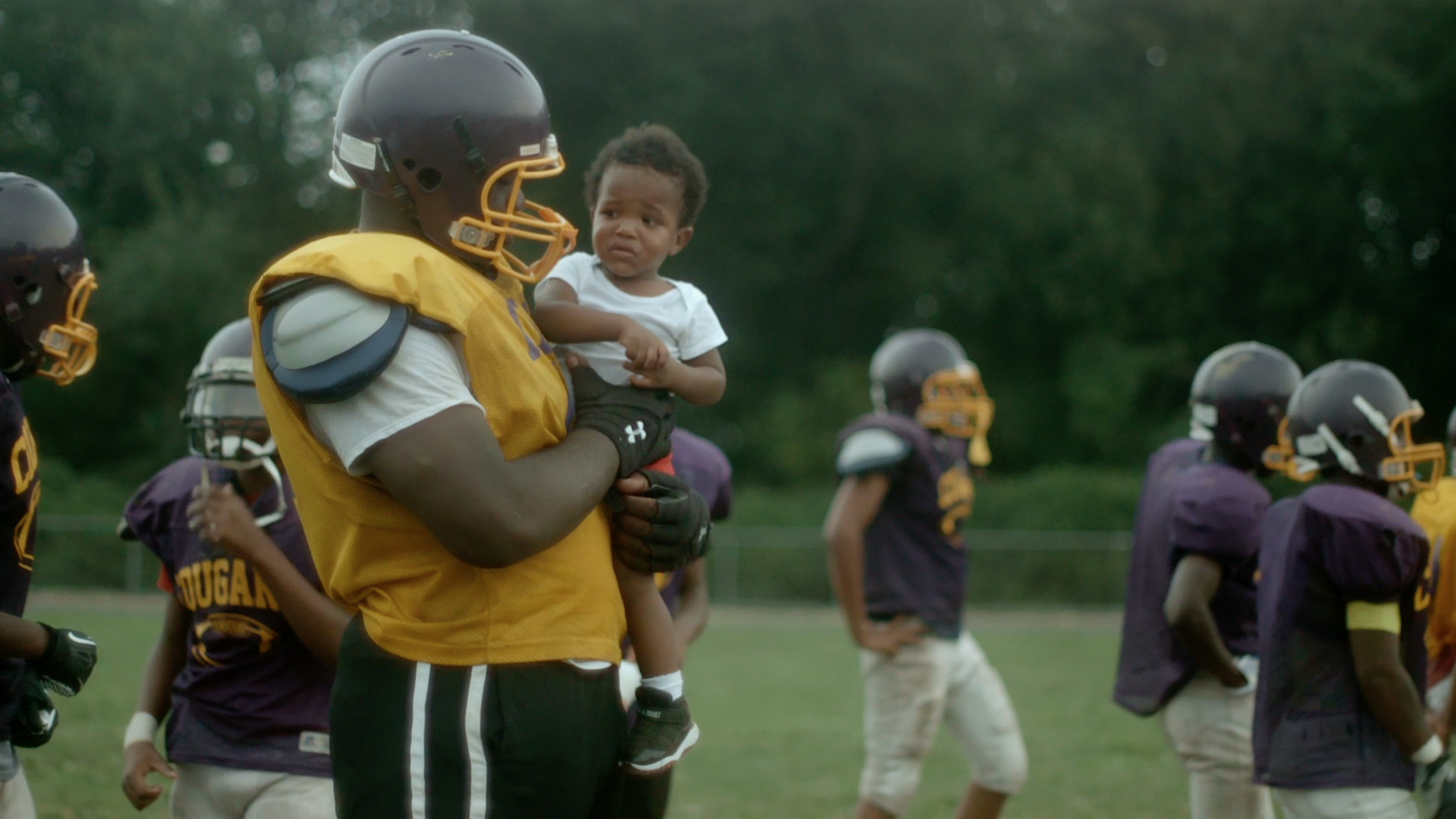 Dontae Angus holds Coach Dunn's son.png