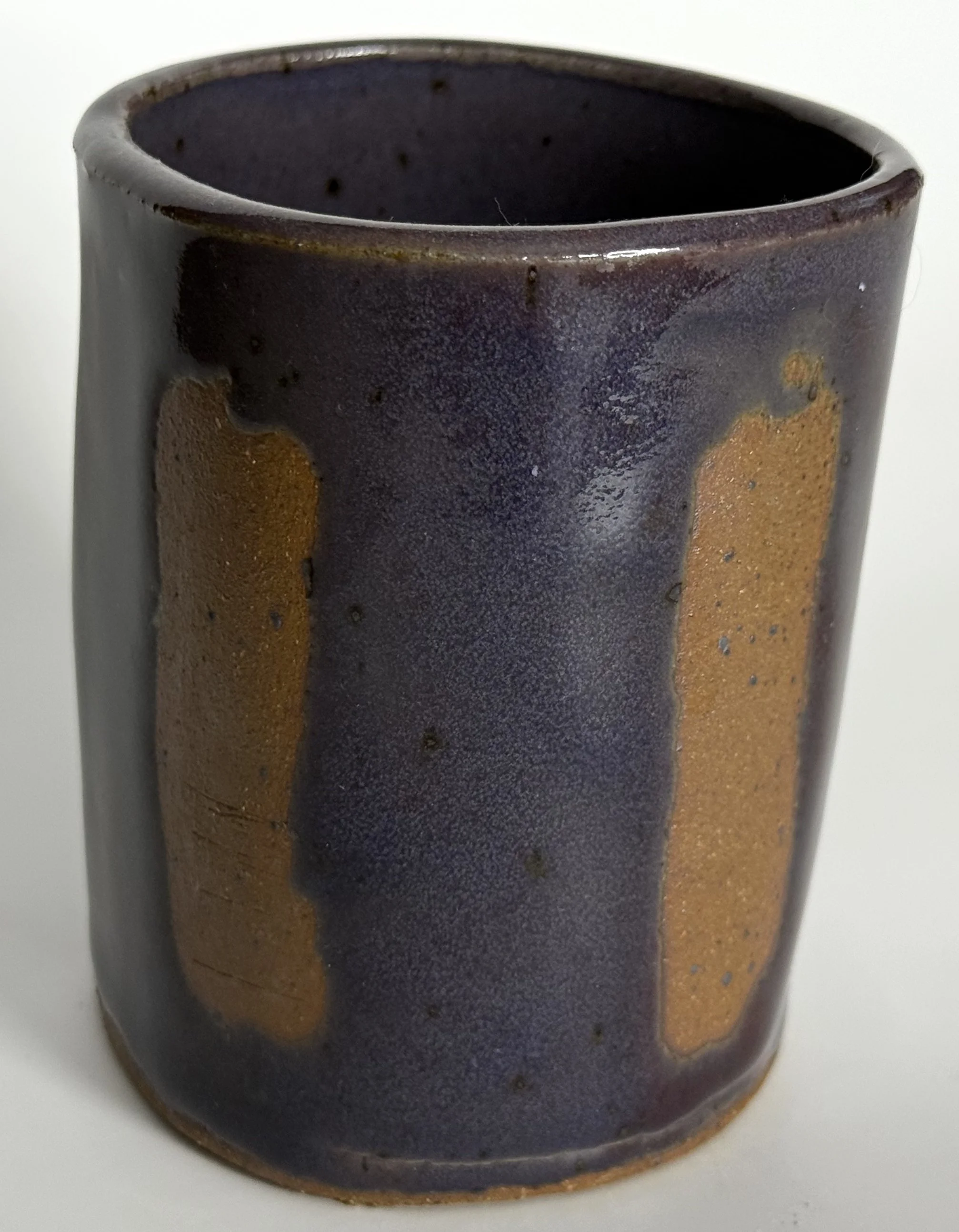 Cup with purple glaze, exposed clay