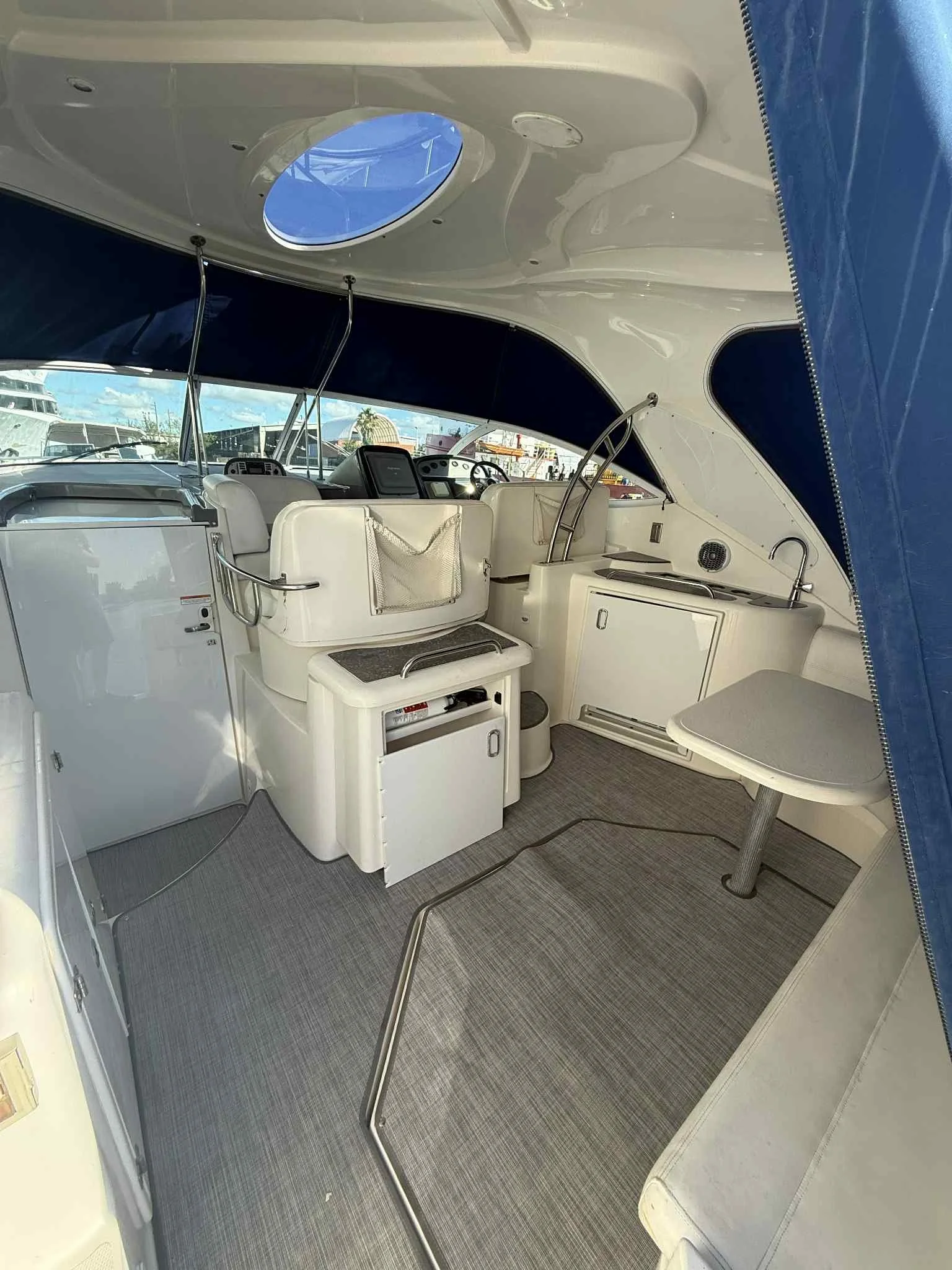 Interior of a yacht with seating, a small countertop, and navigation equipment.