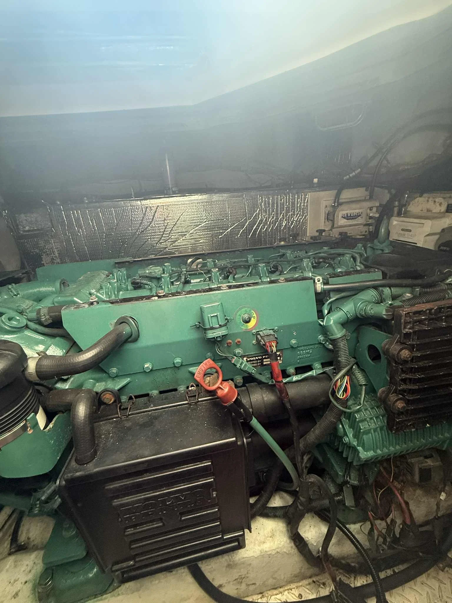 A green industrial or marine engine installed on a boat or in an engine room.