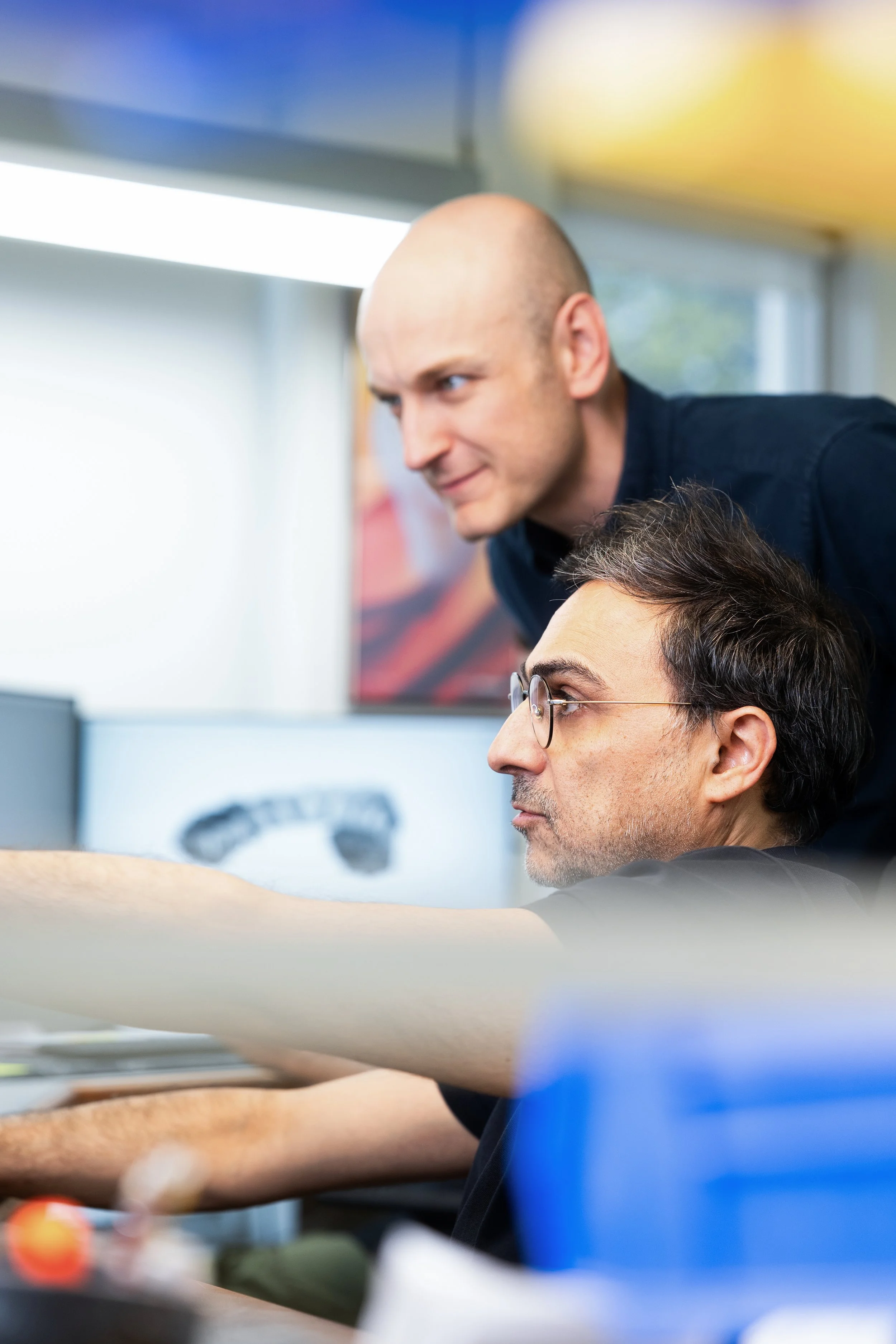 Deux membres de l'équipe de Dental Technique travaillant sur un cas de restauration dentaire et design de prothèse à l'ordinateur, concentrés sur leur tâche.