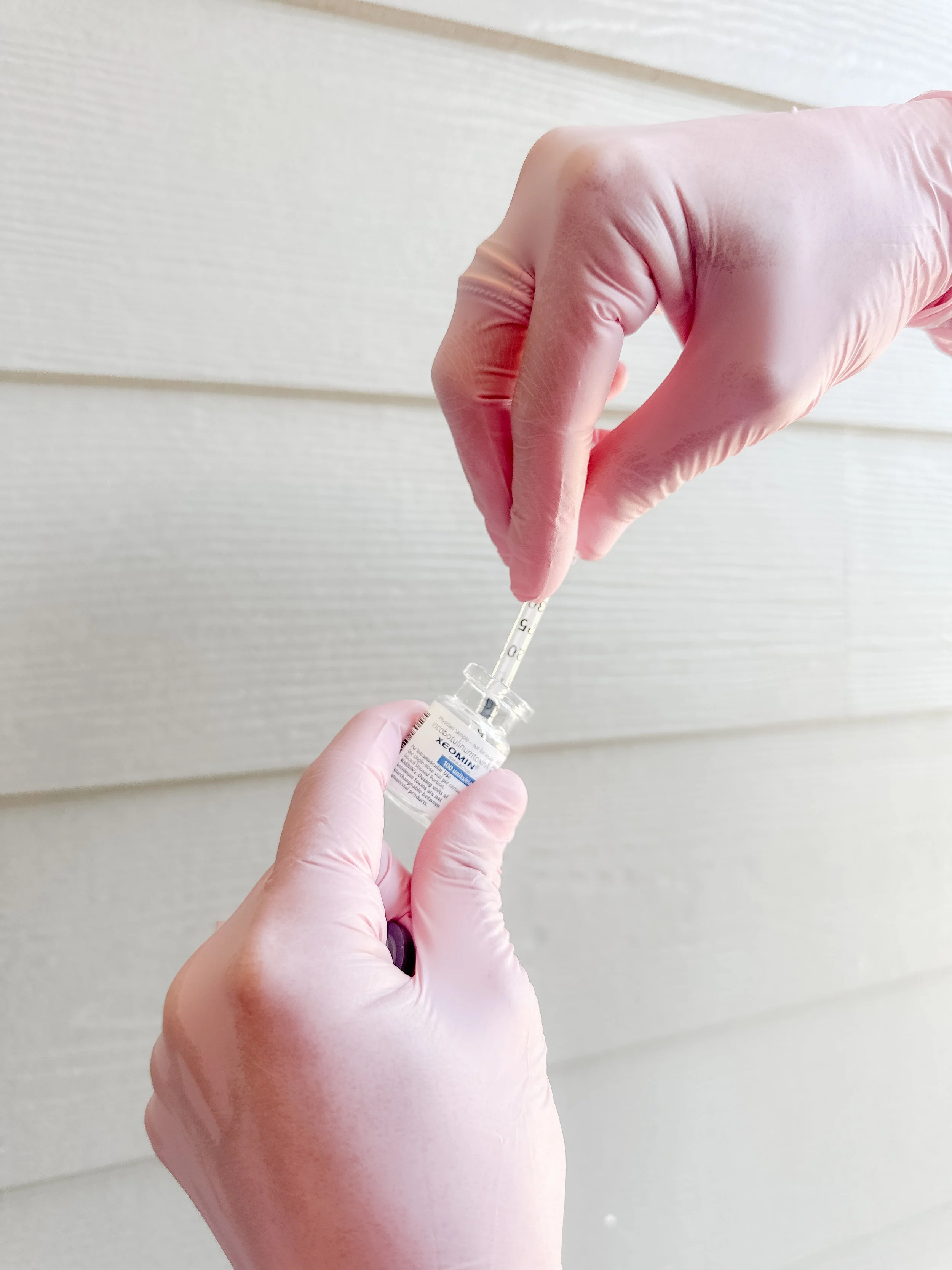 Clinician drawing Xeomin from a vial with a syringe.