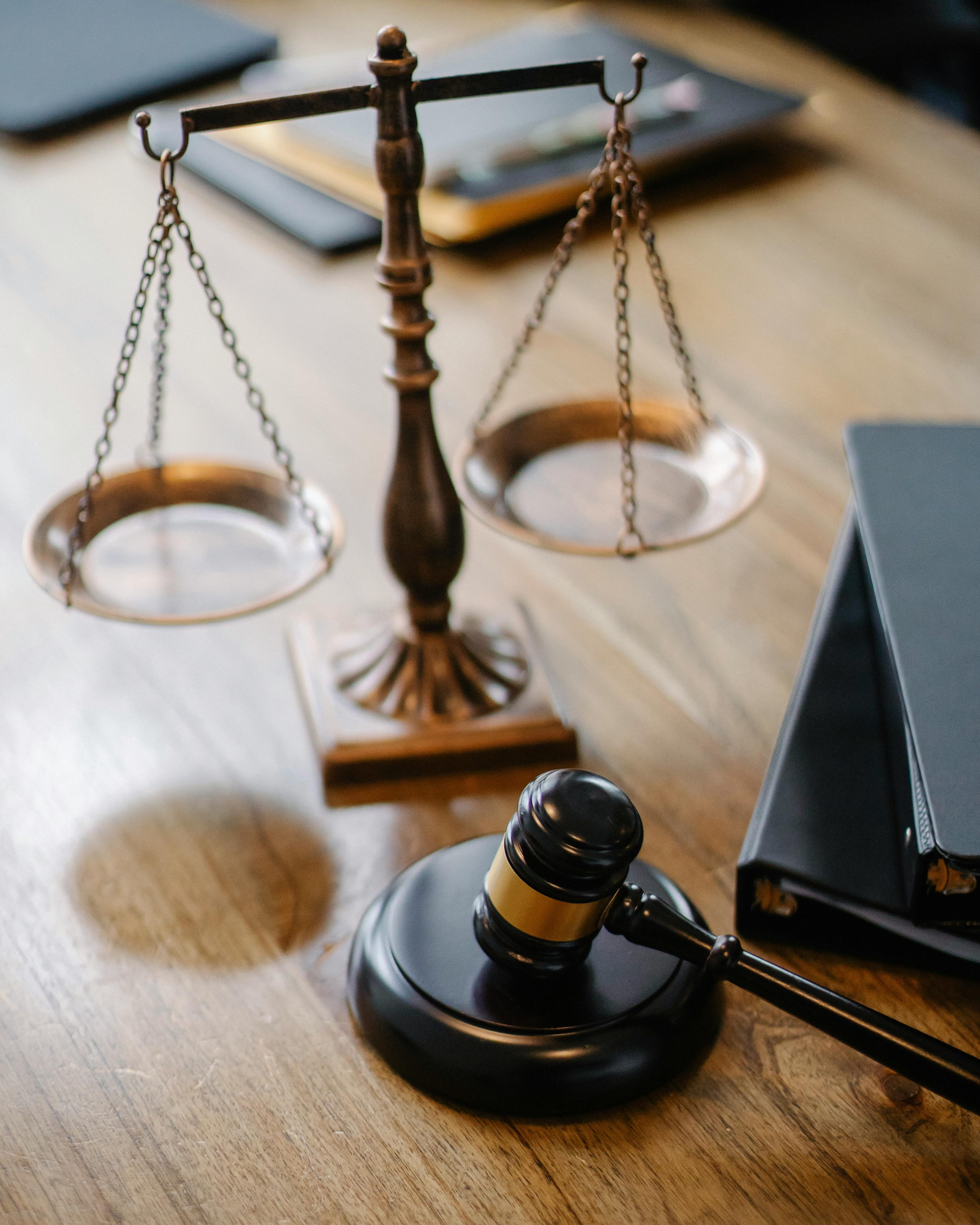 A wooden gavel resting on a light-colored surface with a dark shadow cast nearby.