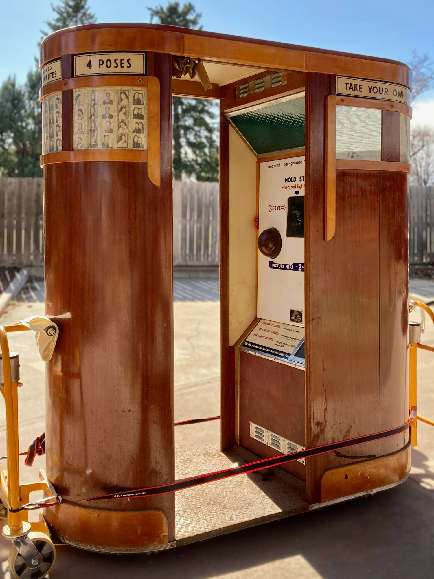 Auto-Photo Model 9 vintage photobooth in a wooden design with signs indicating "4 poses" and "Take your own photos". It has a photo strip slot, instructions, and a window for photos