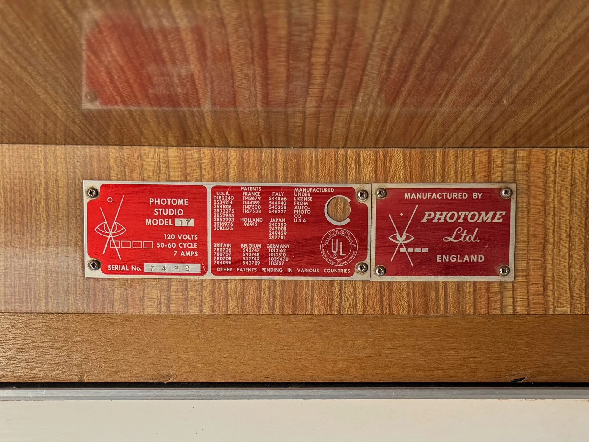 Photo-Me Model 17 red metal nameplate showing details about the manufacture, including serial number, electrical specifications, patents, and manufacturer information from England.