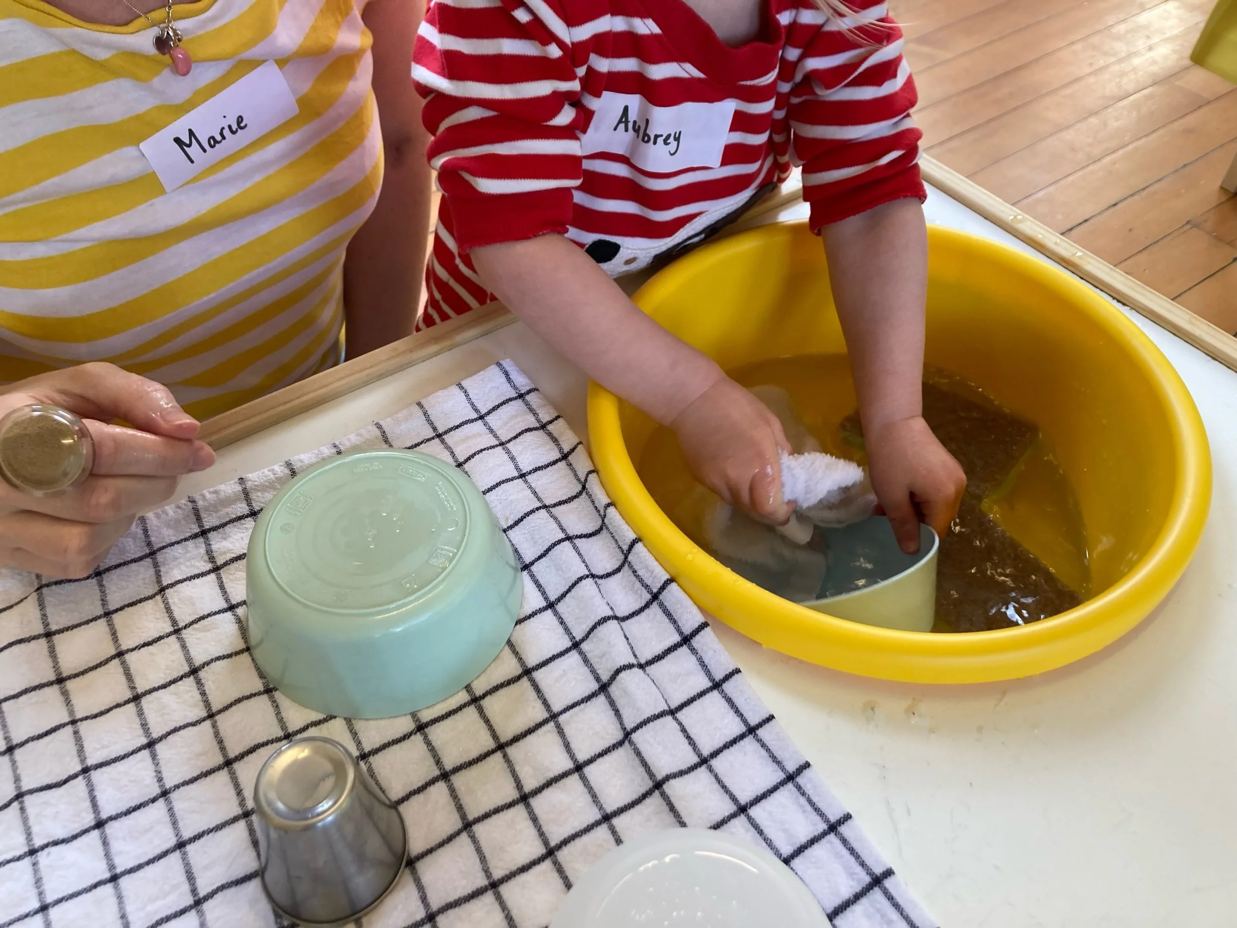 toddler washing toys in a bowl