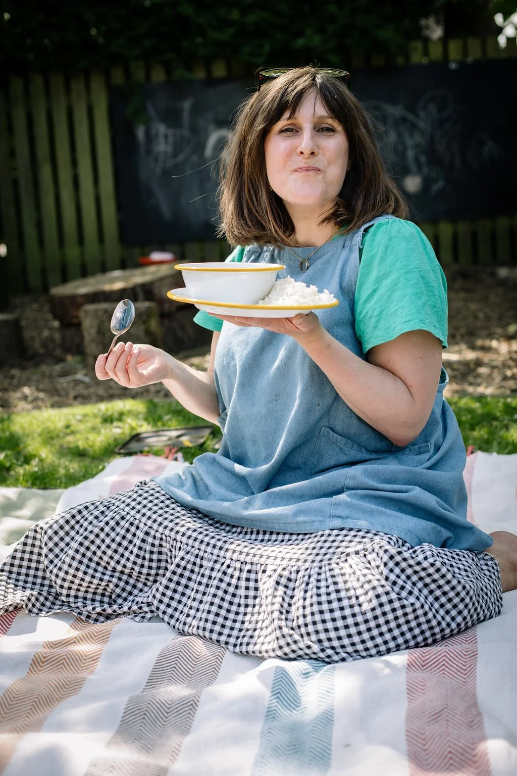 Woman eating from a bowl in a garden