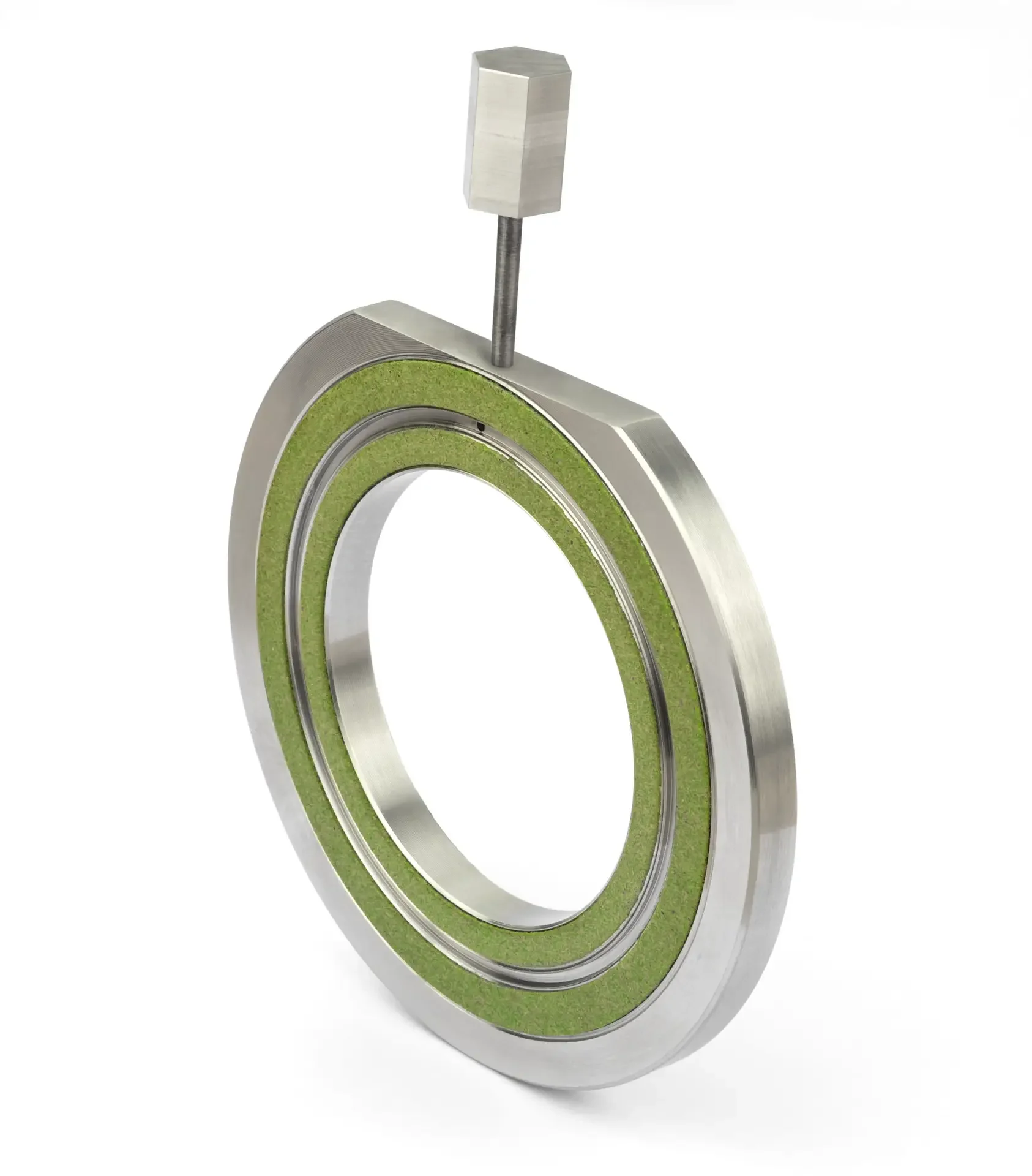 Close-up of a metal bearing with green seals, with a small metal tool resting on top.