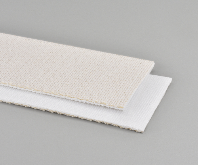 Two rectangular pieces of cream and white fabric stacked on a gray background.