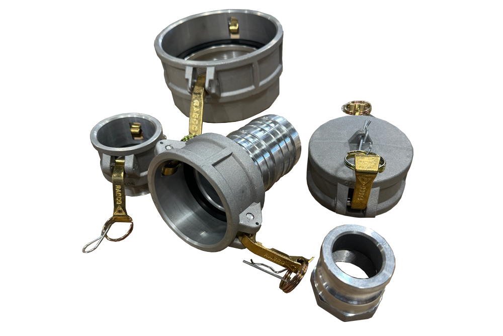 Silver metal camlock couplings and parts with brass levers and latches on a brown surface.