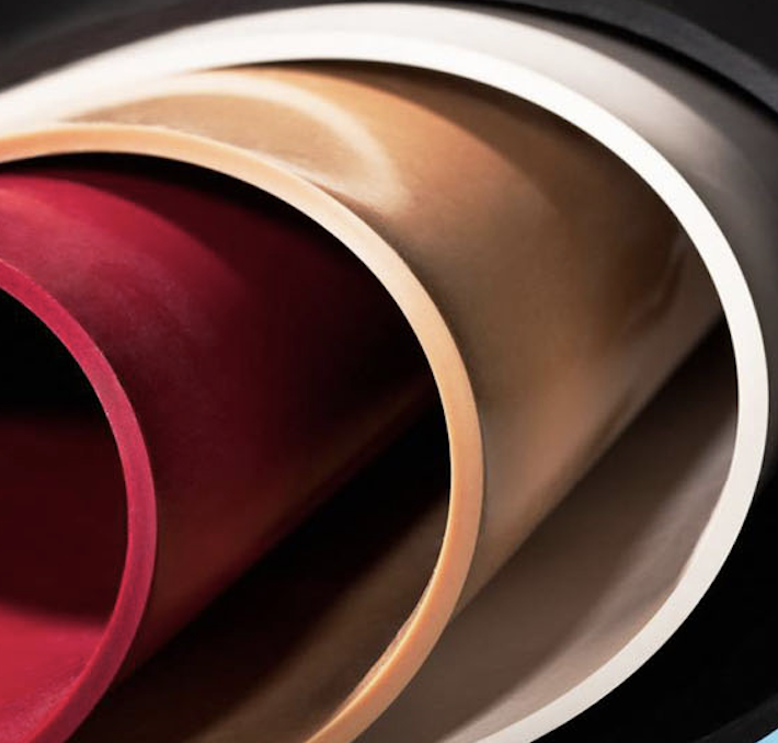 Close-up of sheet rubber or rolls of materials in beige, red, and black colors.
