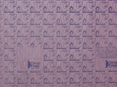 Close-up of a surface covered with small printed logos and text, including repeated words 'Garlock', 'G', and 'Flange Free'.