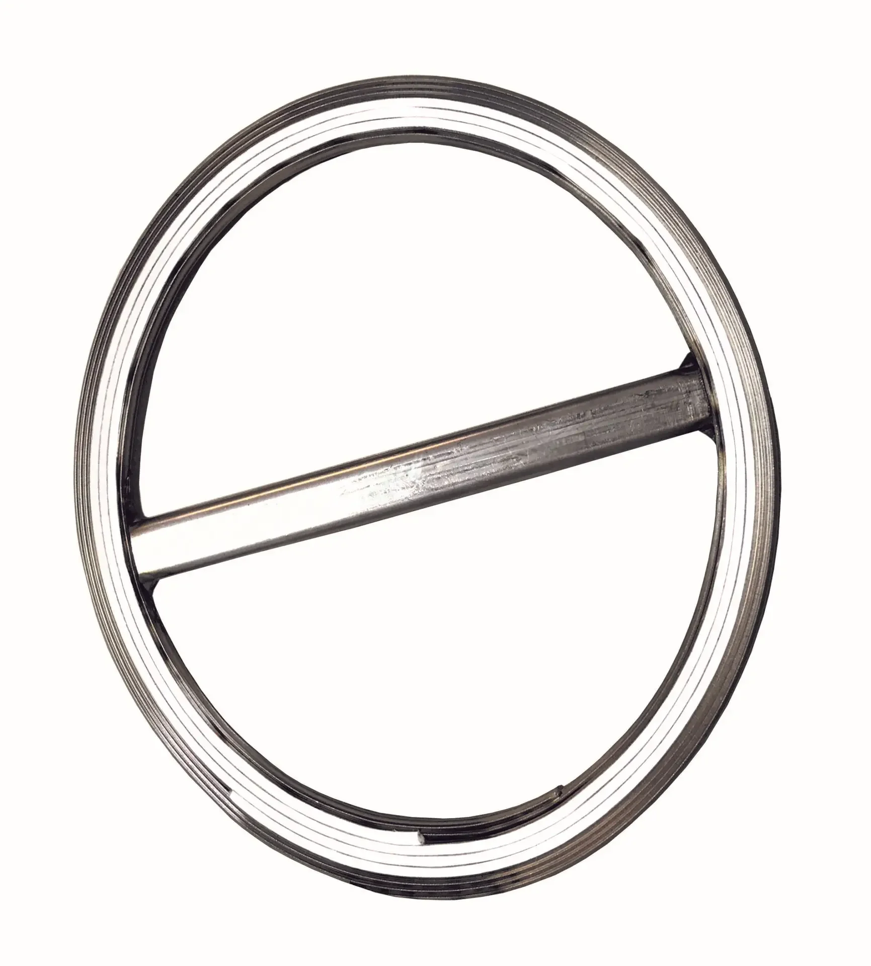 Close-up of a circular metallic object with a horizontal bar through its center, resembling a steering wheel or a large wheel.