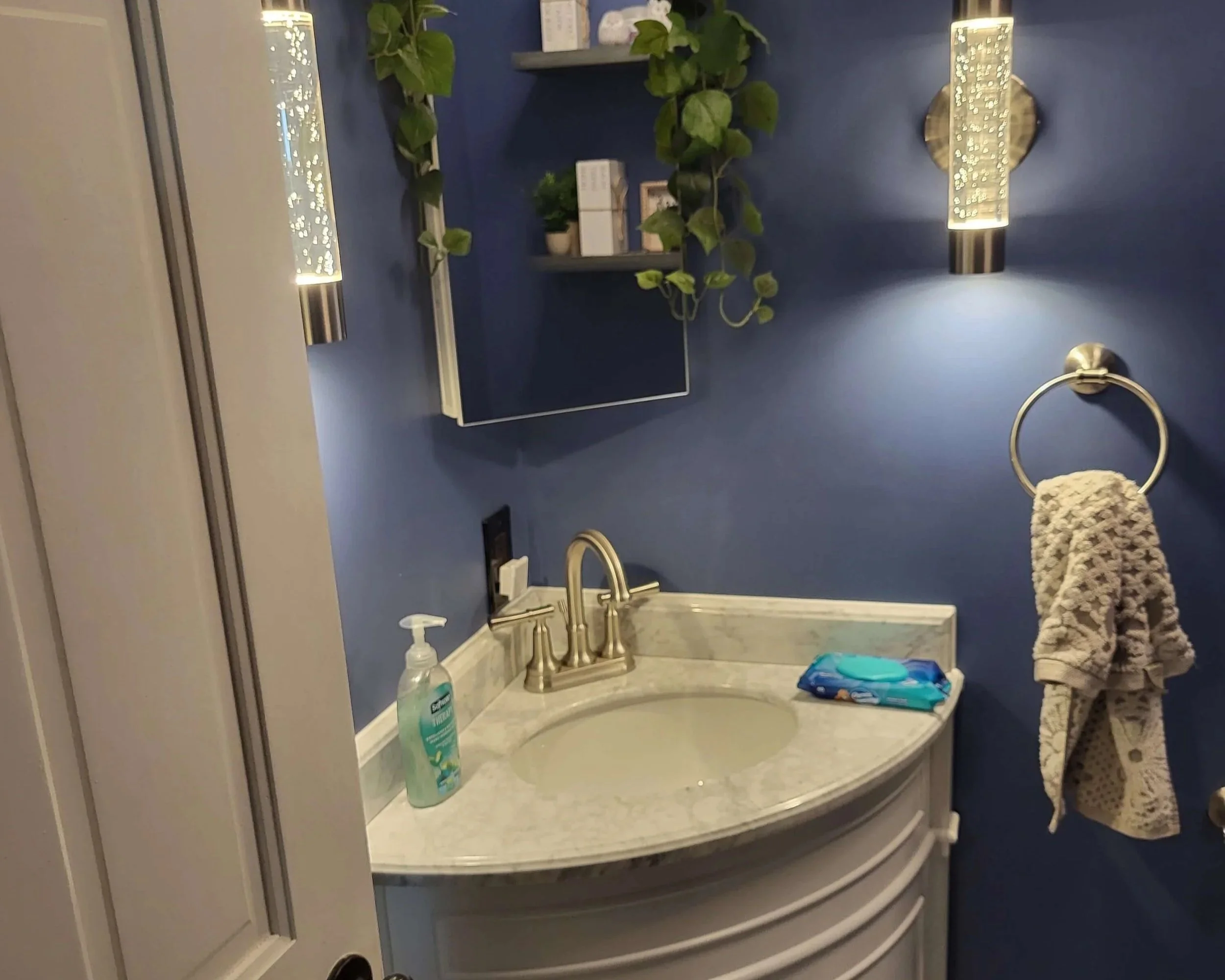 DLR Construction half bathroom renovation featuring a modern white vanity custom lighting and deep blue walls in Cleveland Ohio