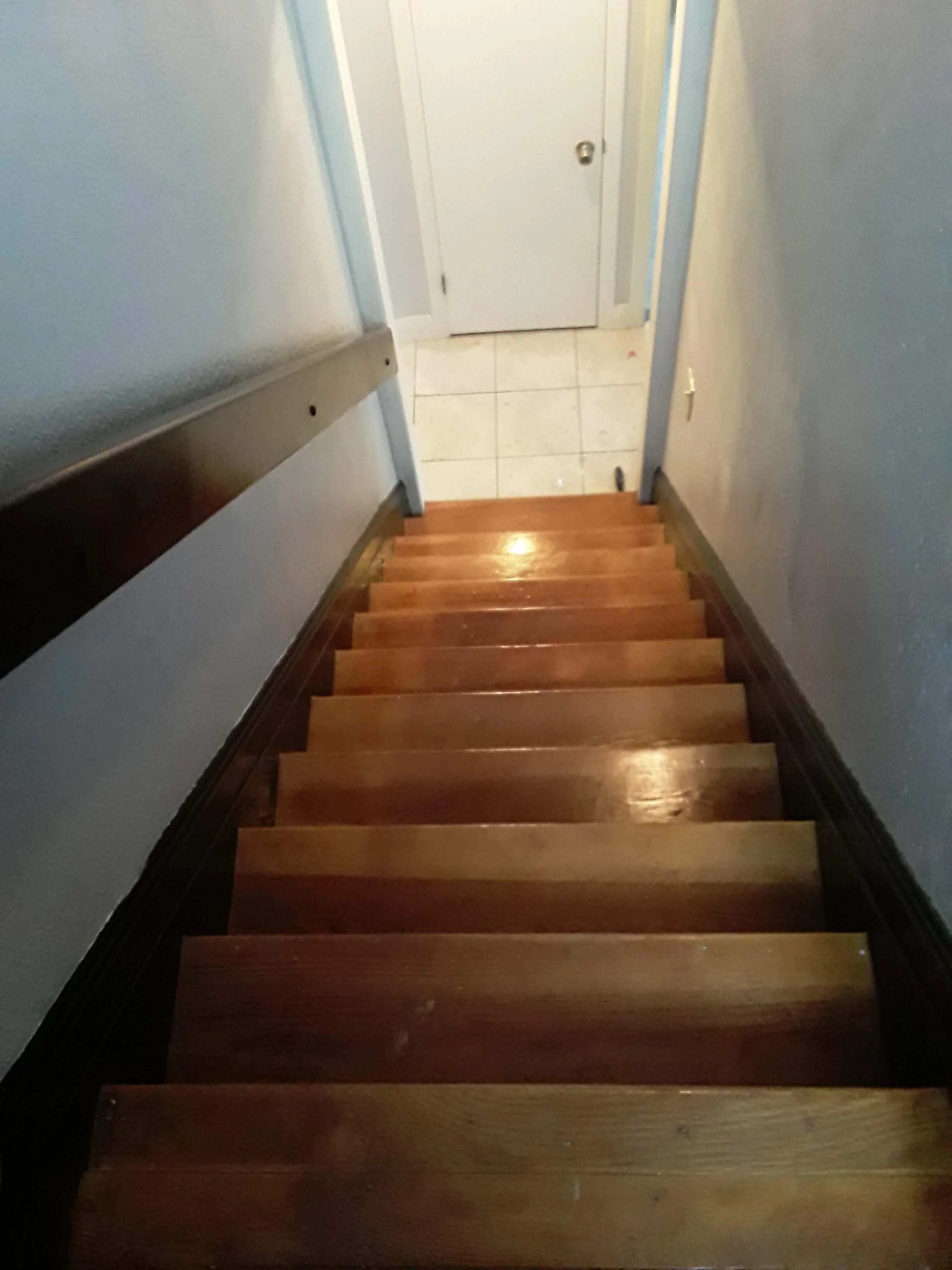 Custom sanded and refinished residential hardwood staircase matching a full-home floor restoration project by DLR Construction in Cleveland, Ohio.