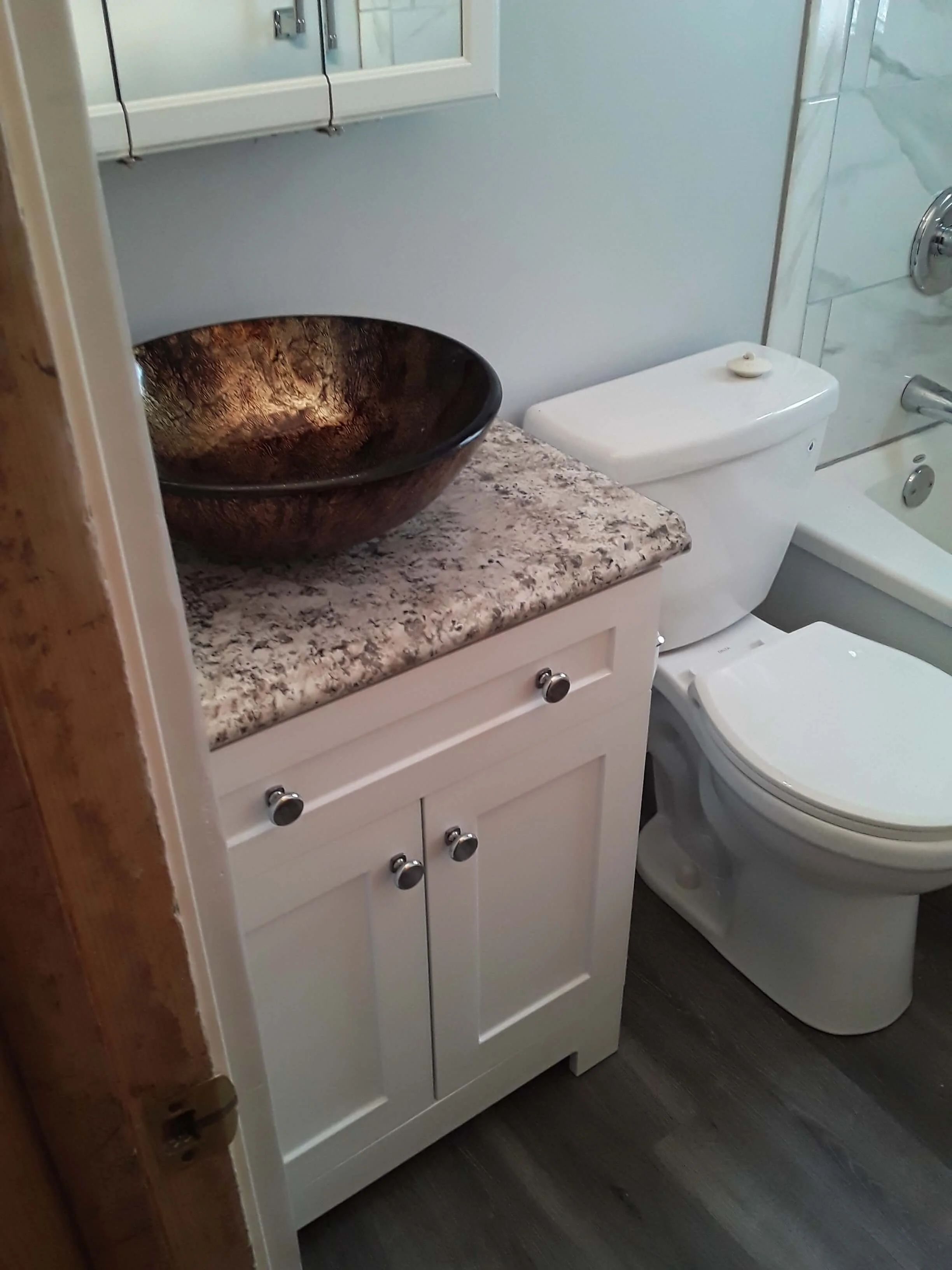 DLR Construction custom bathroom remodel with copper vessel sink white vanity and granite countertop in Cleveland Ohio
